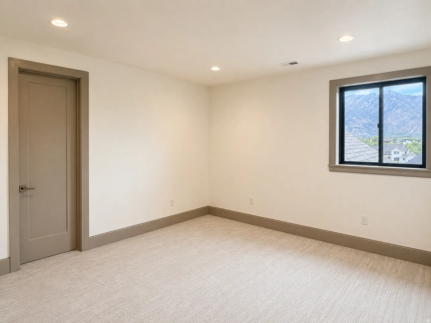 Recessed lighting, neutral-toned walls, and soft pile carpeting