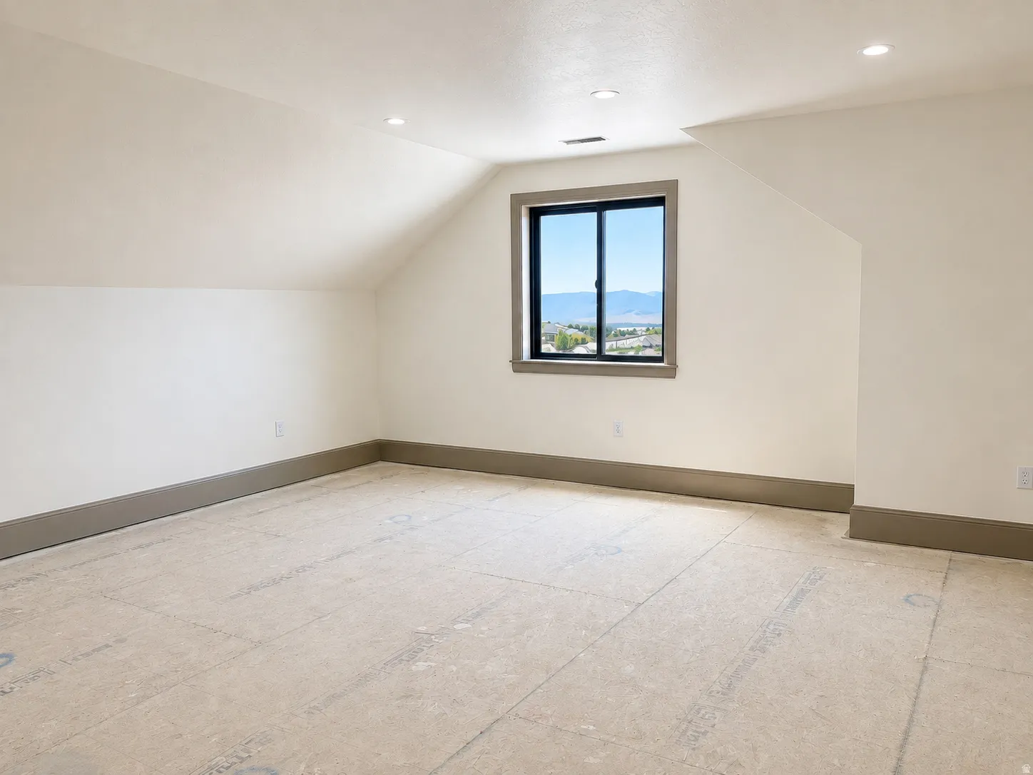 Bonus room featuring an angled ceiling, recessed lighting, and a single window with dark trim