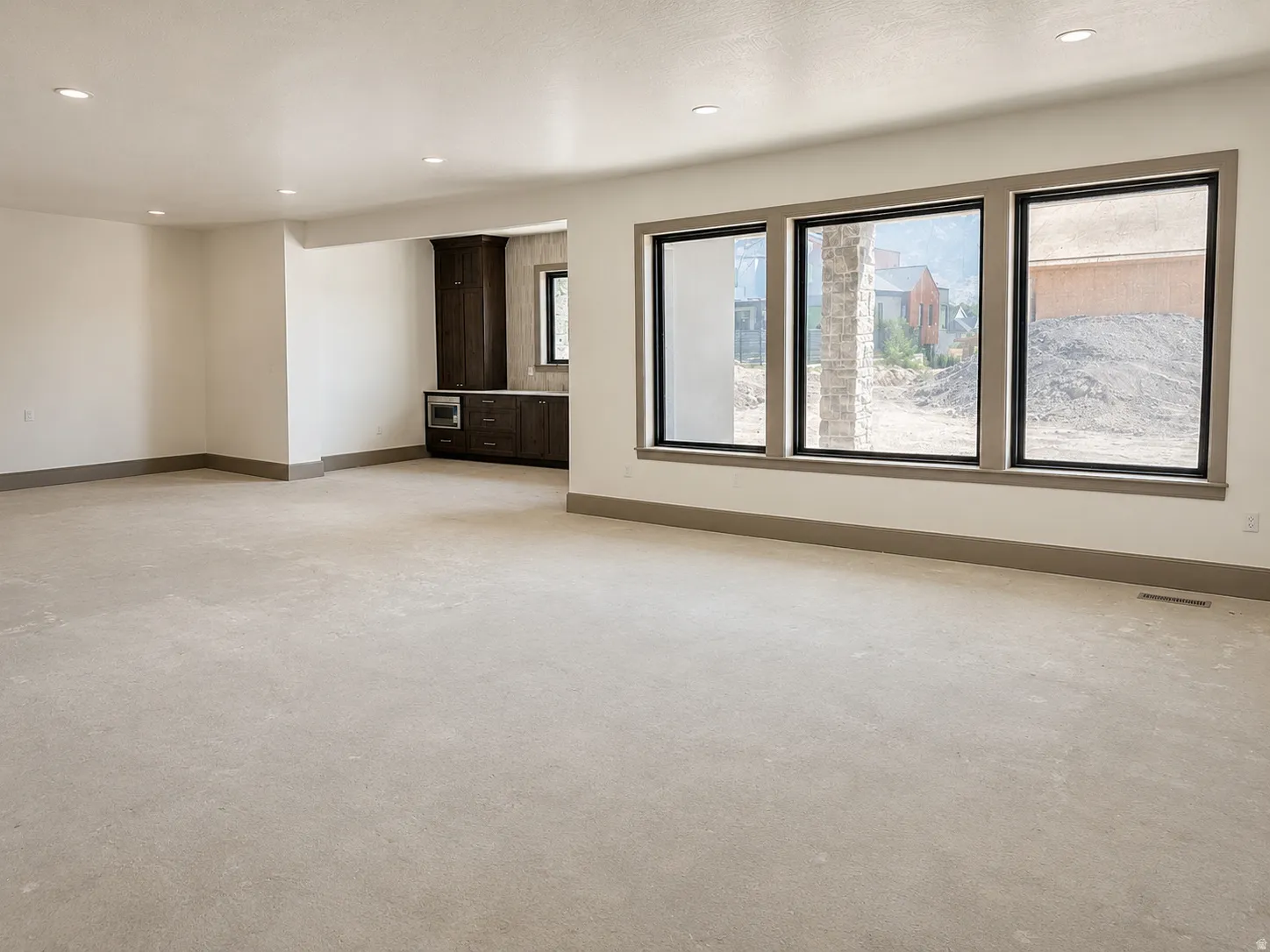 Open concept room featuring a recessed wet bar with built-in cabinetry, an integrated microwave, and a dark countertop