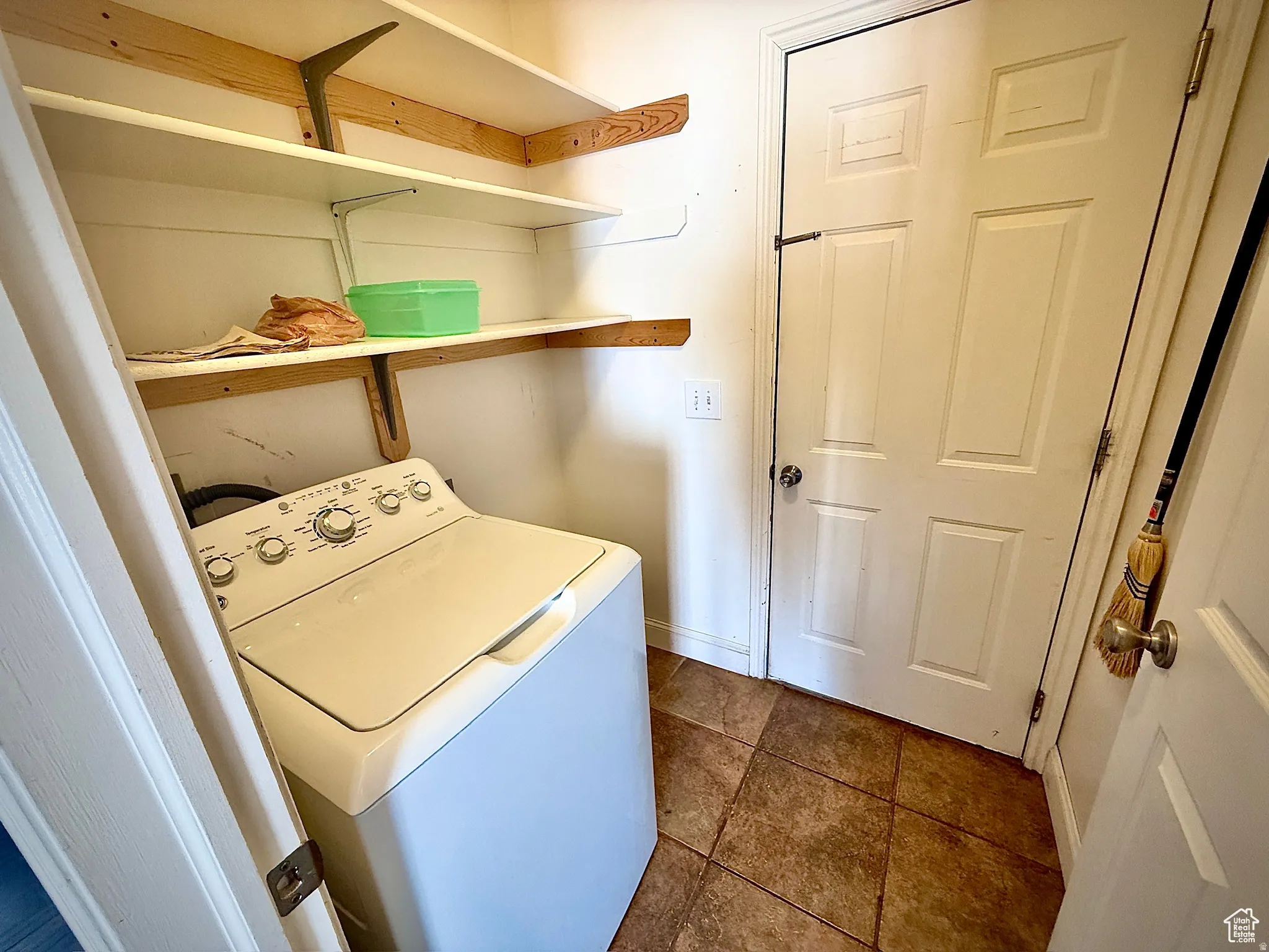 Laundry area featuring washer / dryer and dark tile patterned floors