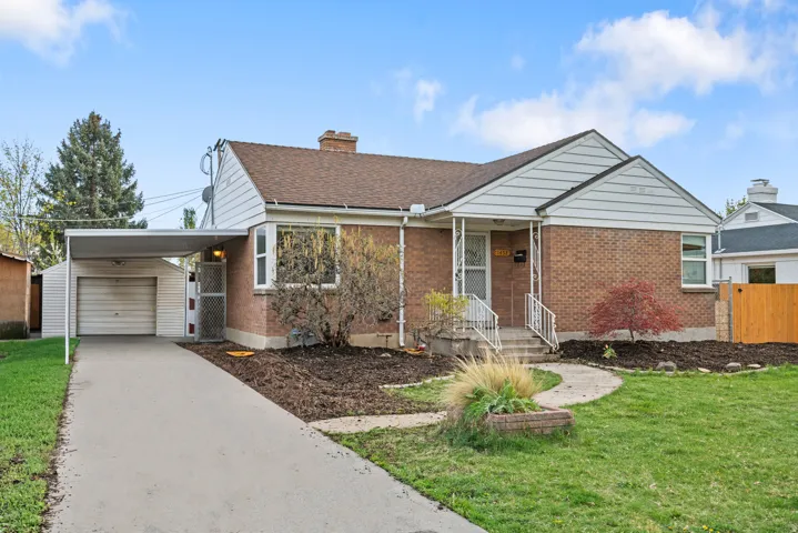 Ranch-style house featuring an outbuilding, brick siding, concrete driveway, a garage, and a shingled roof