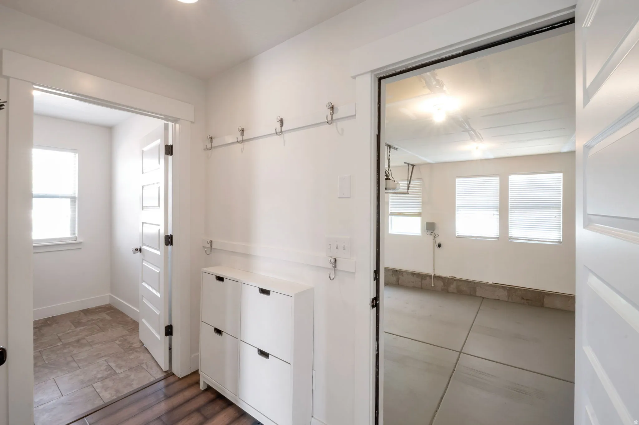 Entryway featuring wood-finish flooring, built-in coat hooks, and a shoe cabinet