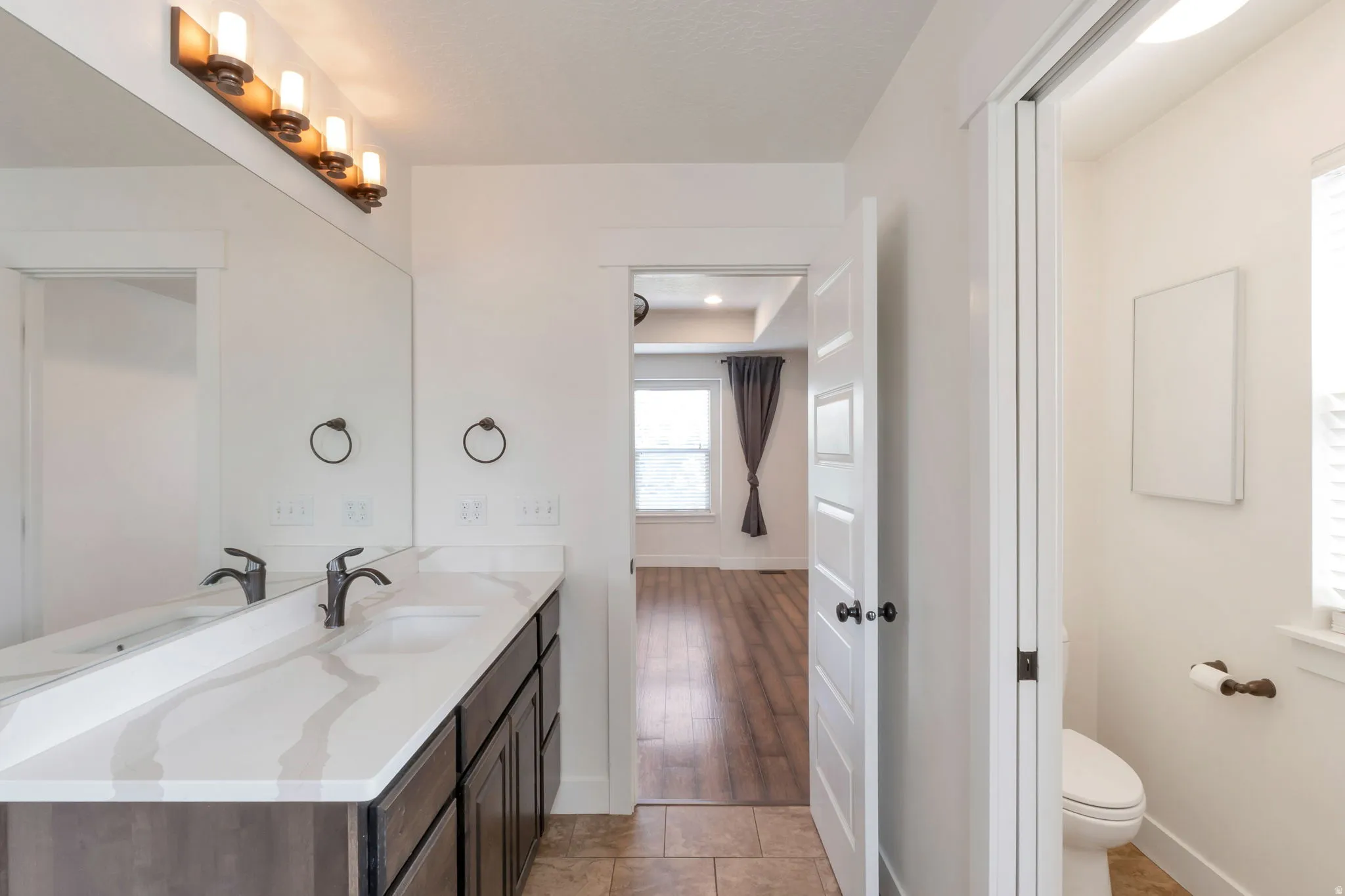 Double vanity with a white countertop and dark wood-finish cabinetry