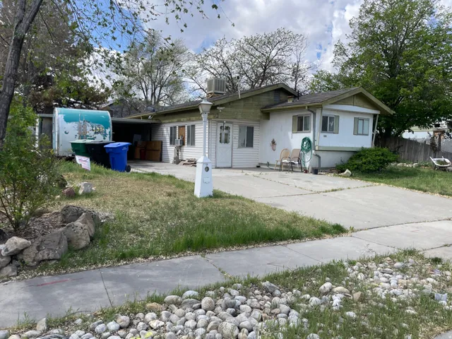 View of front of house featuring a patio, a carport, and driveway