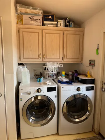 Laundry area featuring light wood-finish cabinetry providing ample storage