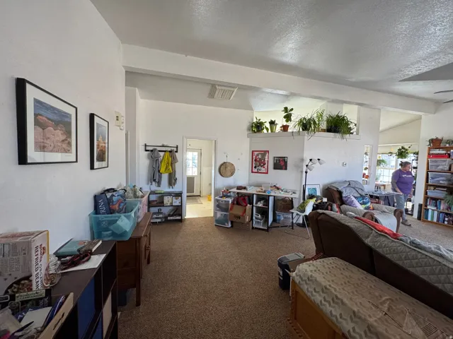 Open concept living area featuring a neutral carpet and bright white walls
