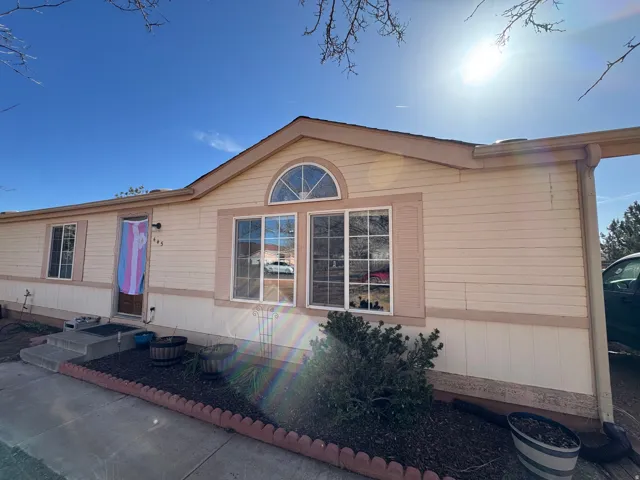 Light-toned exterior siding with contrasting trim, featuring a prominent arched window above a large picture window