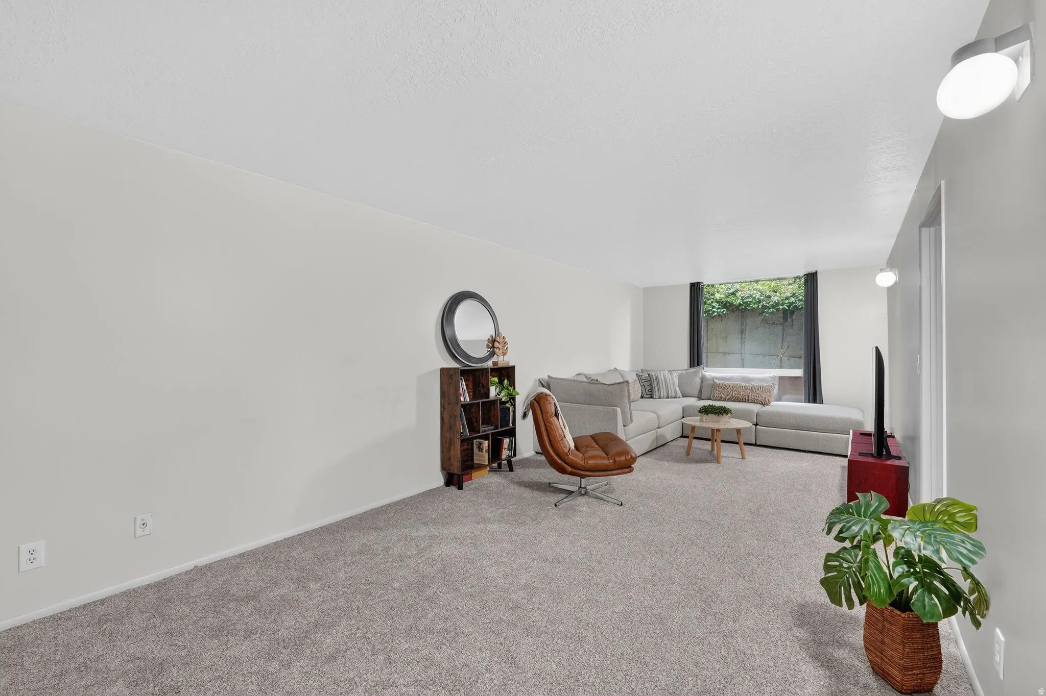 Carpeted living area featuring baseboards and a textured ceiling