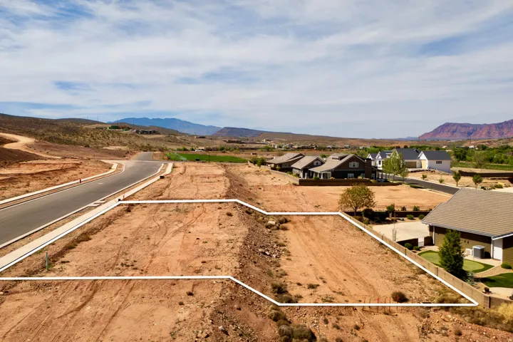 Aerial perspective of suburban area featuring a mountainous background and property parcel outlined