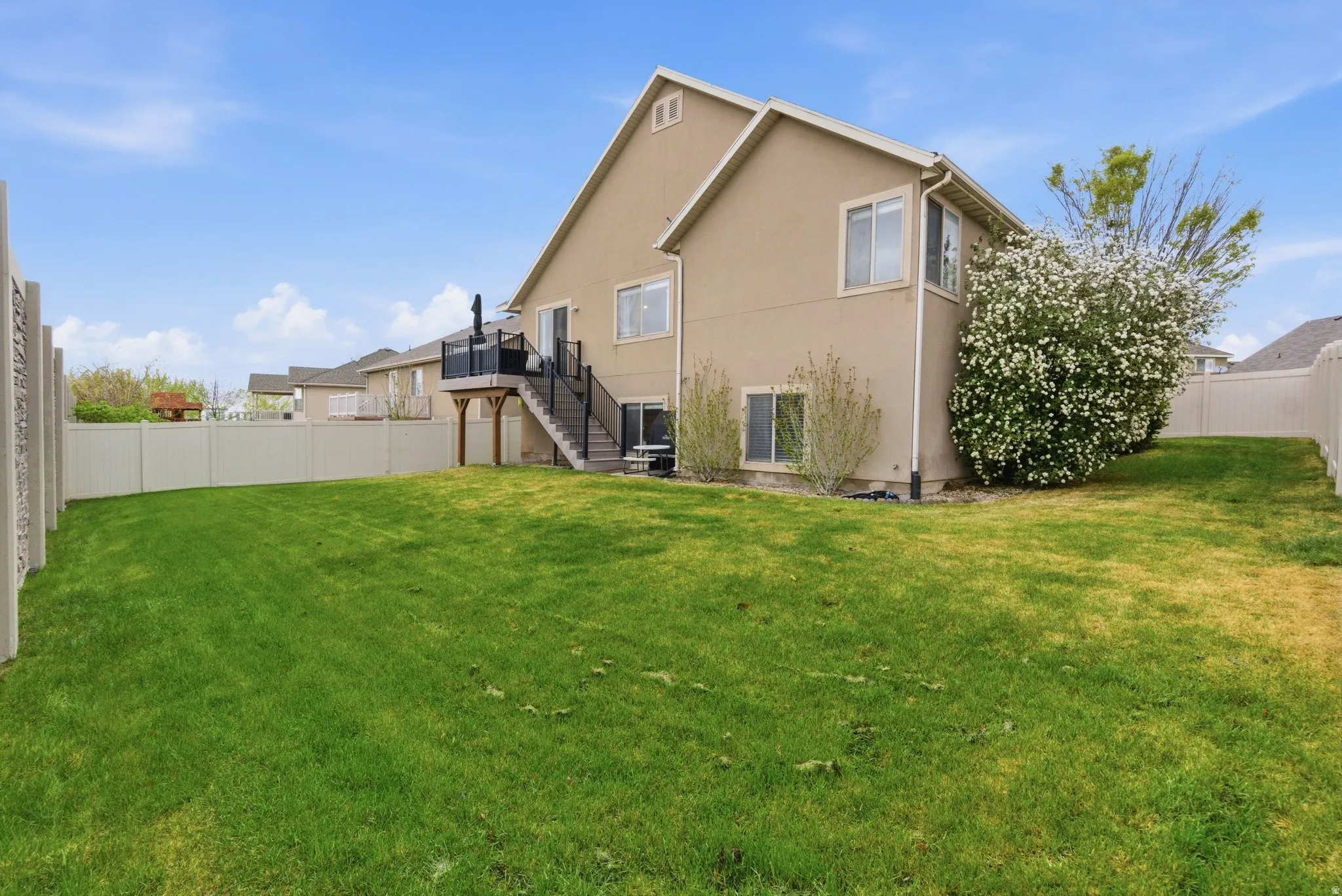 Rear view of property with a fenced backyard and stucco siding