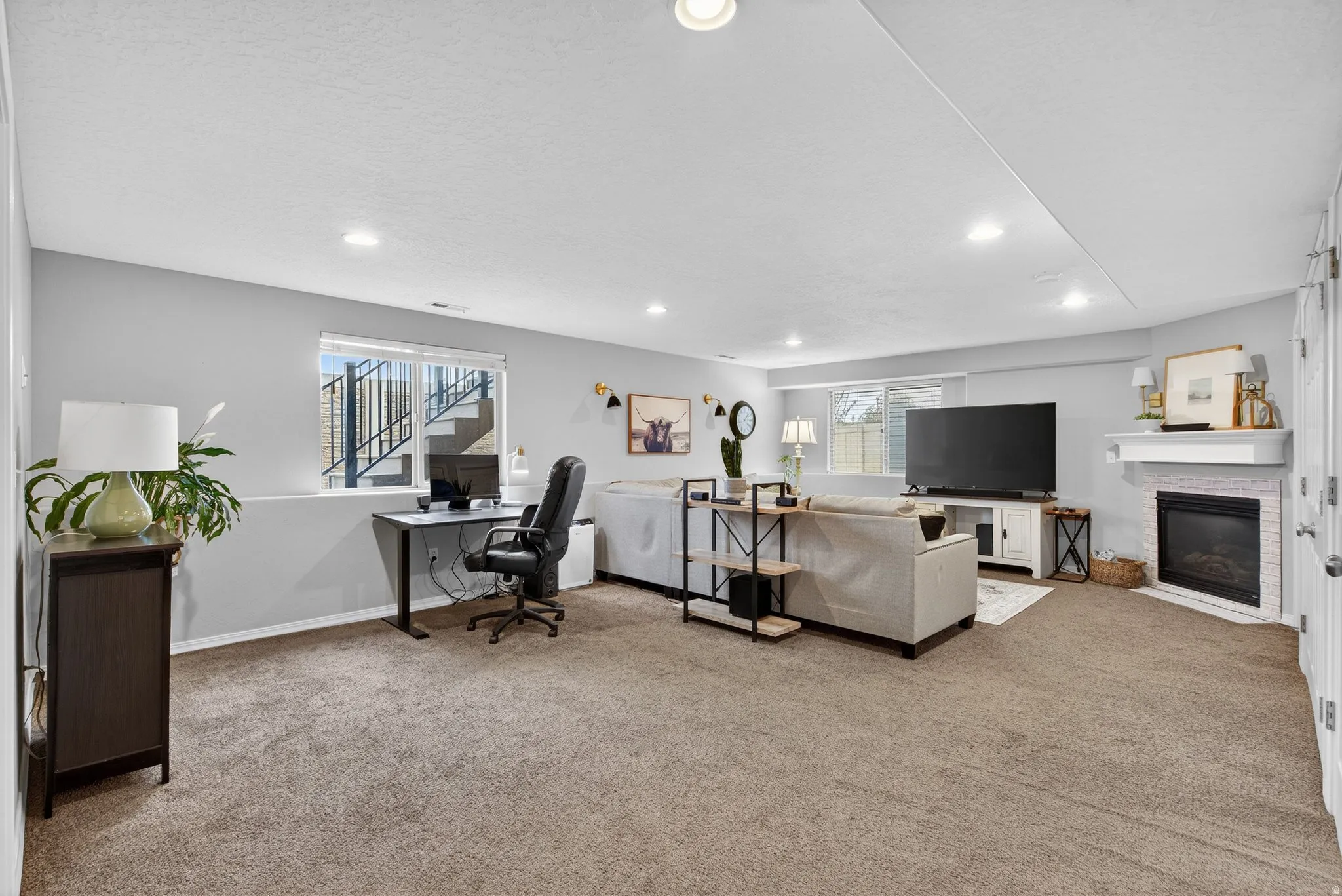 Carpeted office space with a glass covered fireplace and recessed lighting