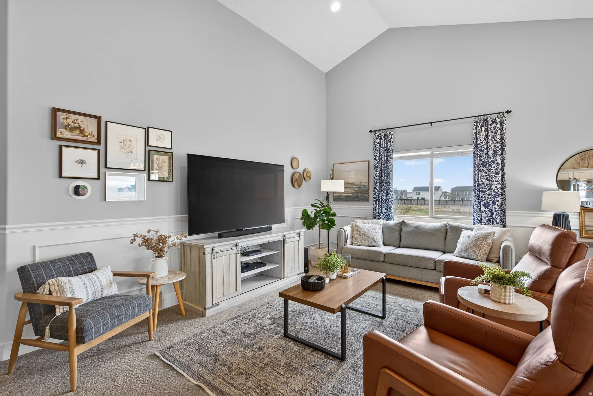 Carpeted living room featuring wainscoting and lofted ceiling