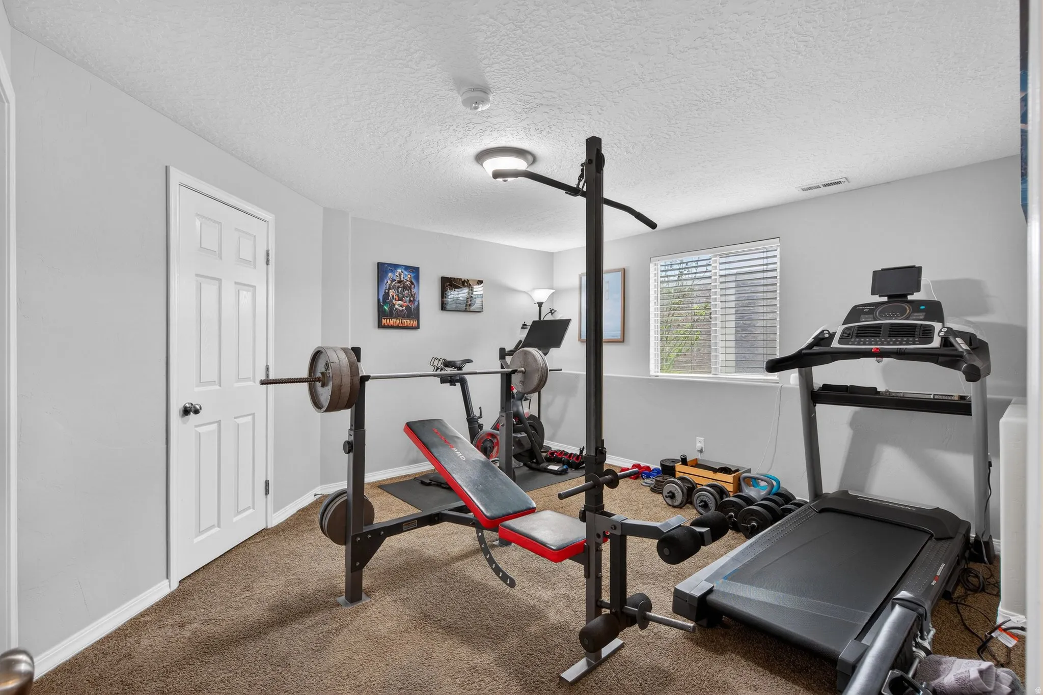 Workout room featuring carpet flooring and a textured ceiling