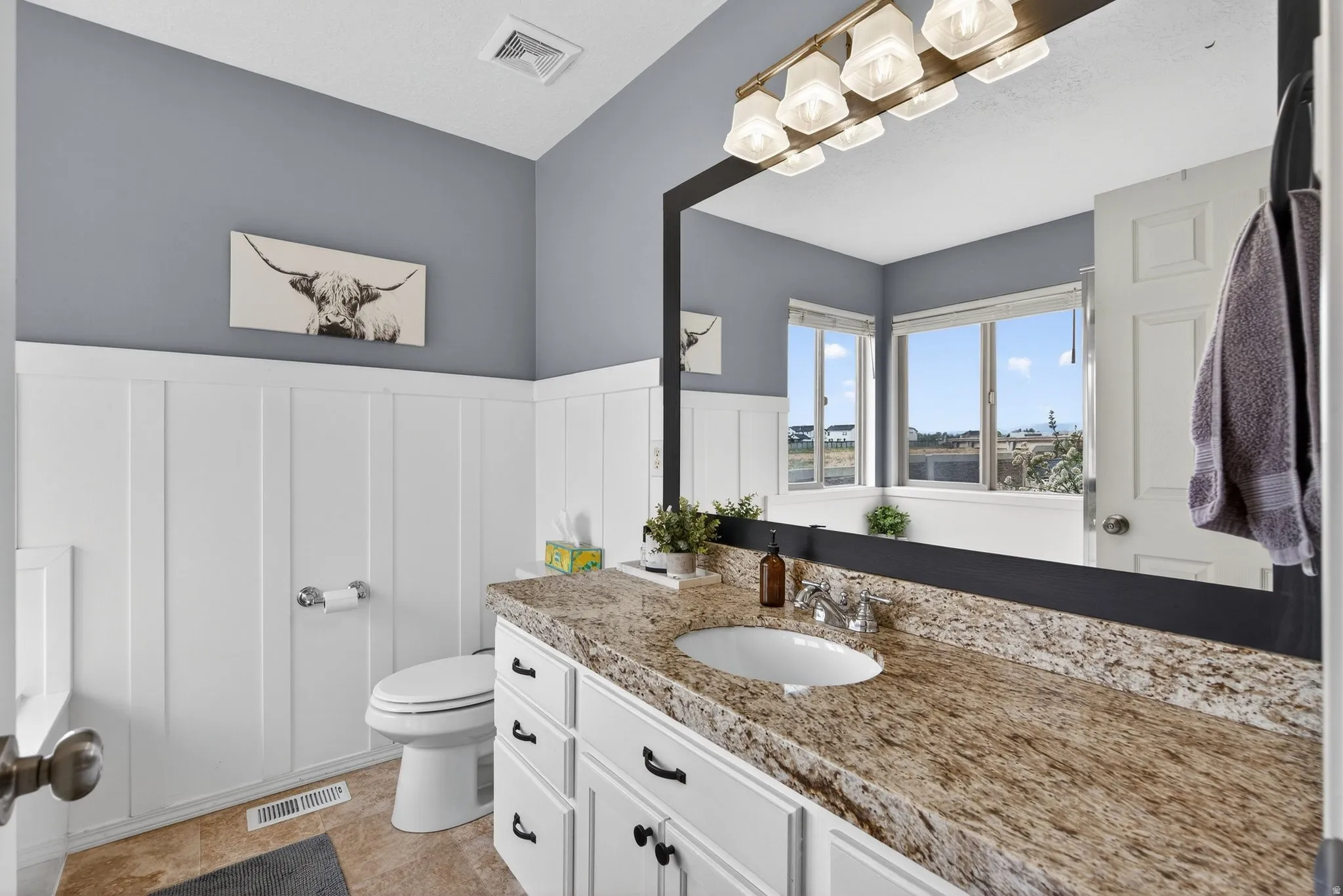Bathroom featuring vanity and a wainscoted wall
