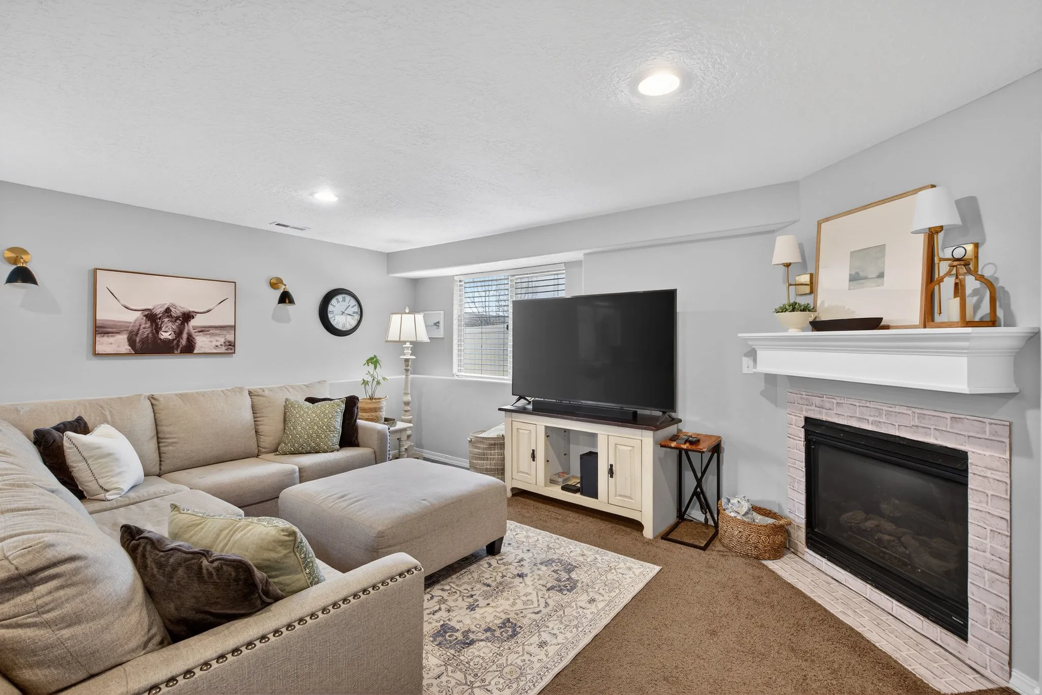 Carpeted living room featuring a textured ceiling, a fireplace, and recessed lighting