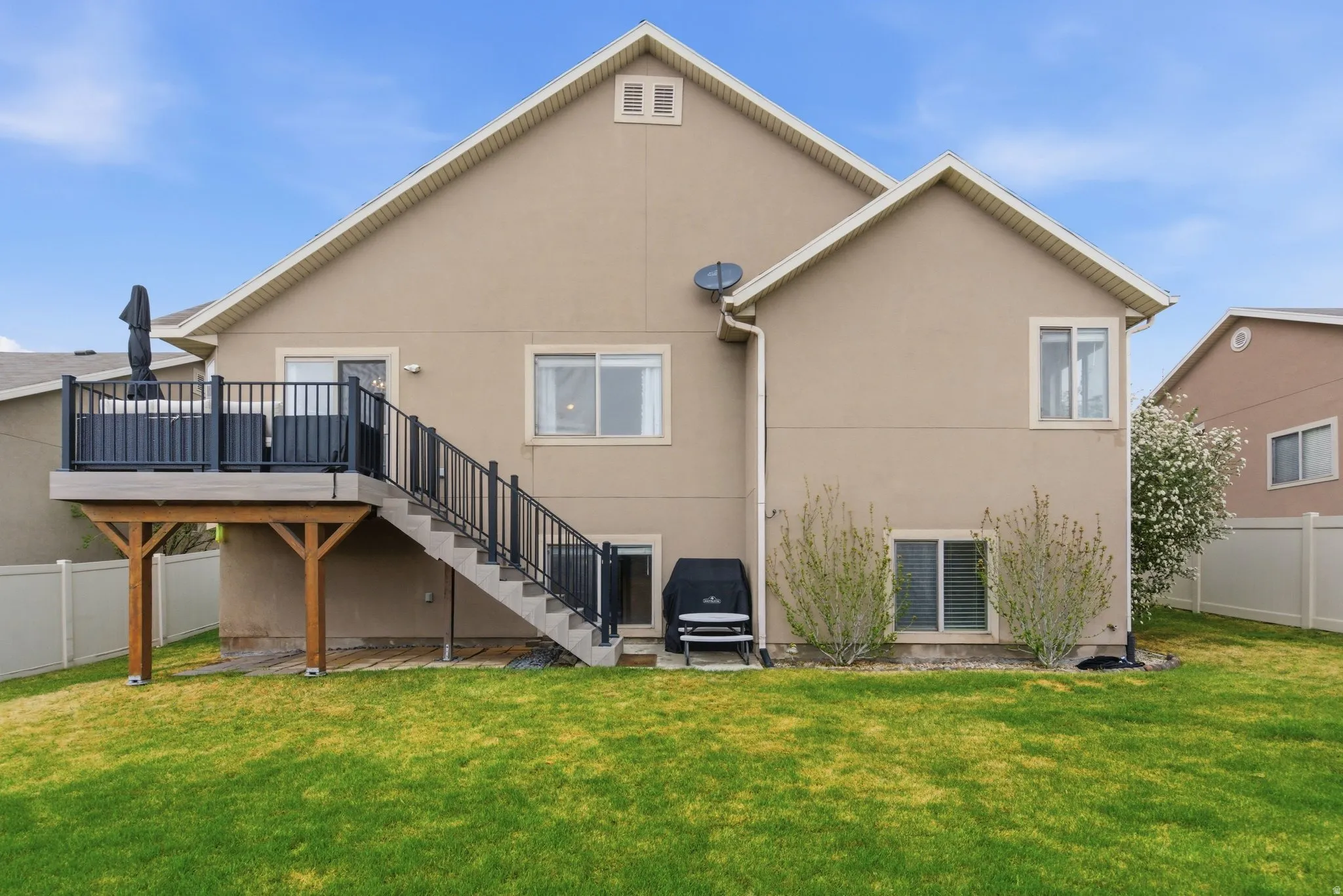 Back of property featuring a patio, stucco siding, and a wooden deck
