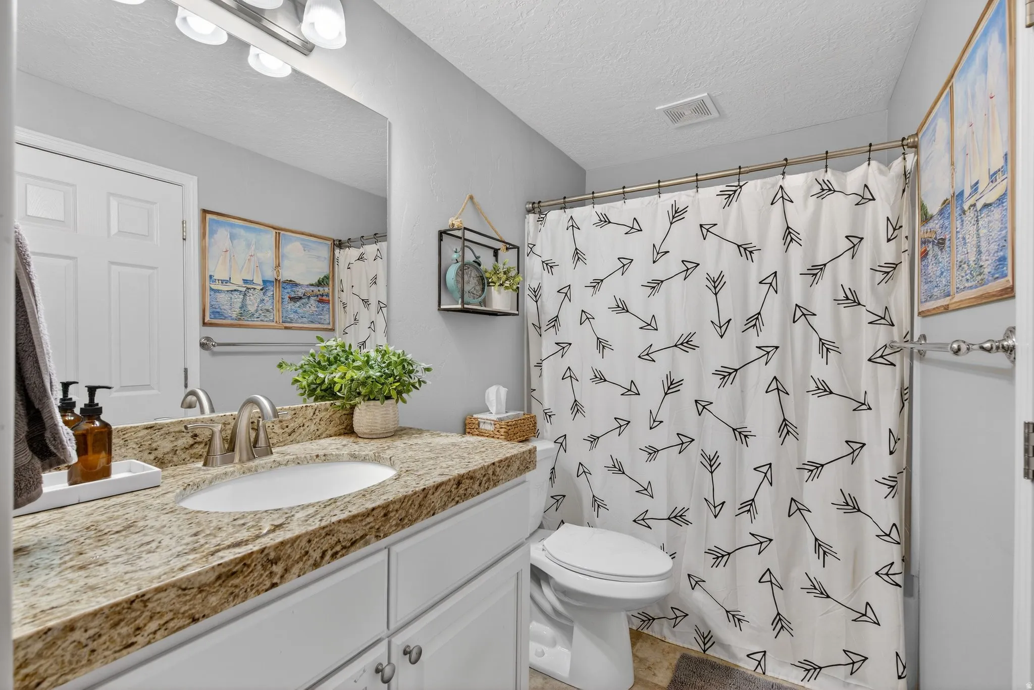 Bathroom featuring vanity, a shower with shower curtain, and a textured ceiling