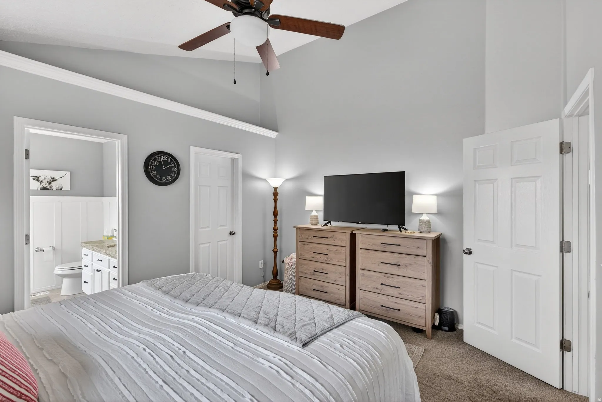 Bedroom featuring lofted ceiling, carpet floors, ceiling fan, and connected bathroom
