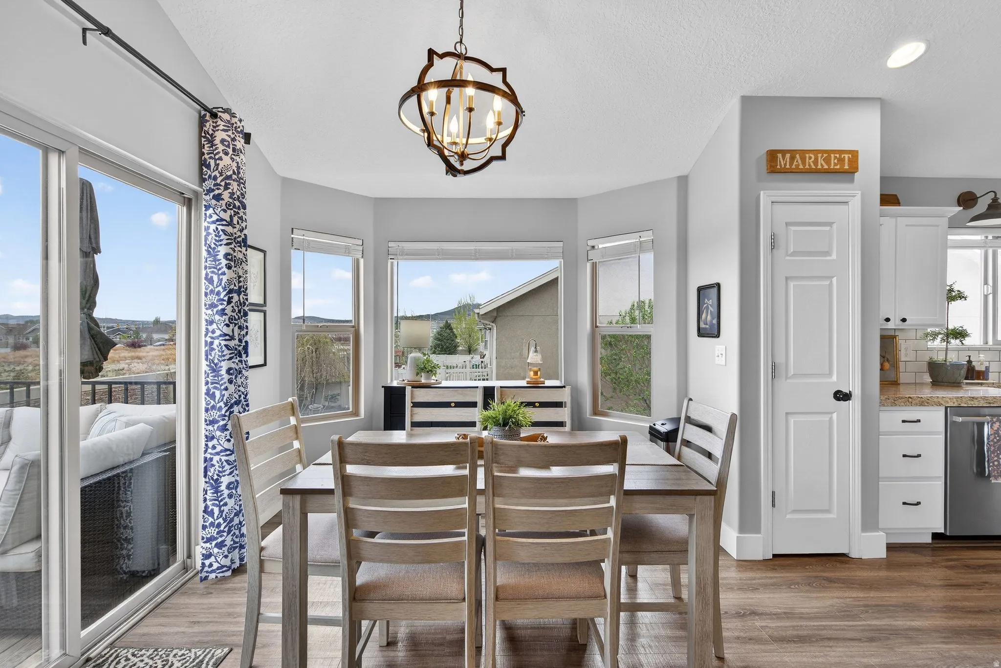 Dining room featuring dark wood-style flooring, hanging lights, and a textured ceiling
