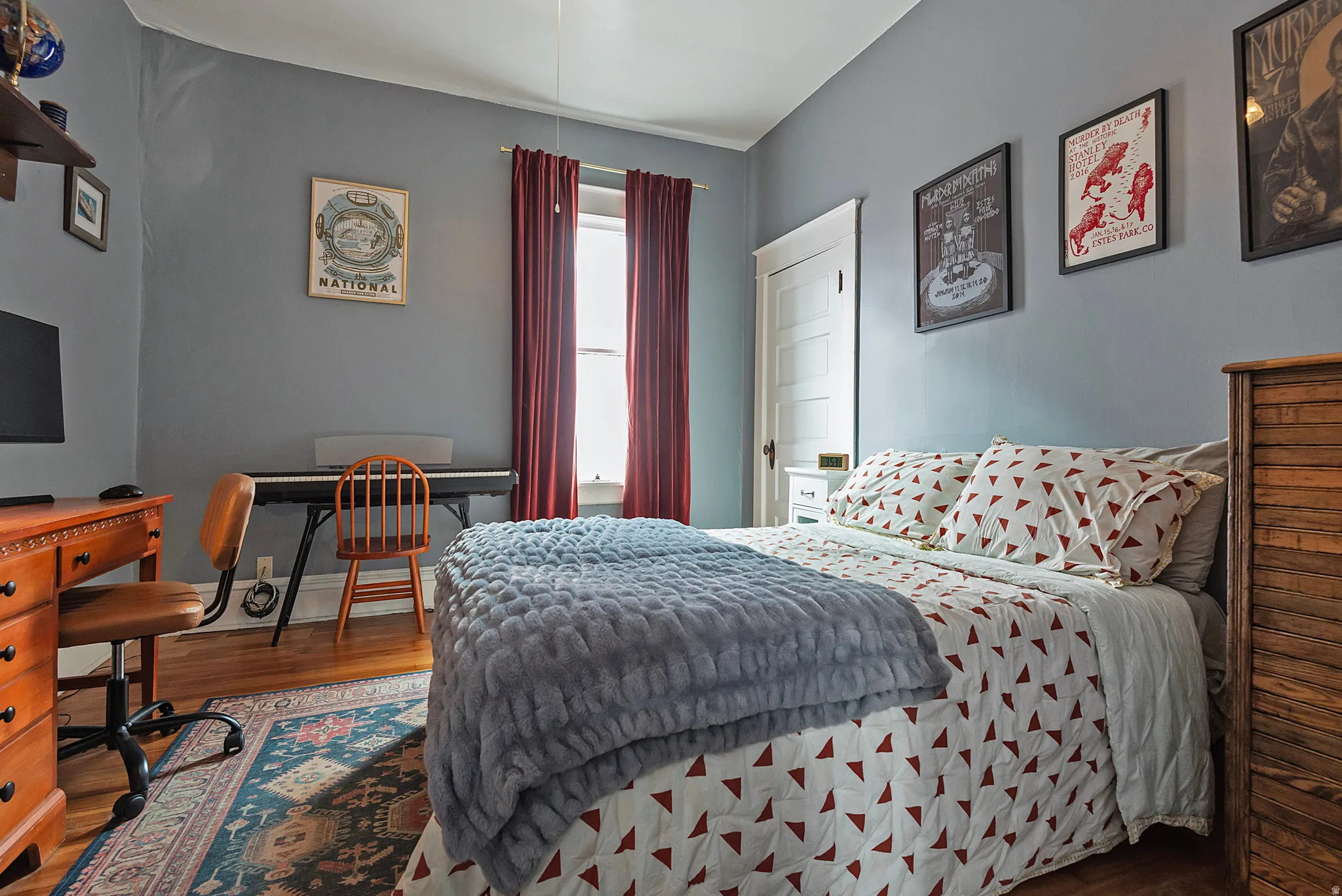 Bedroom with wood finished floors and a desk