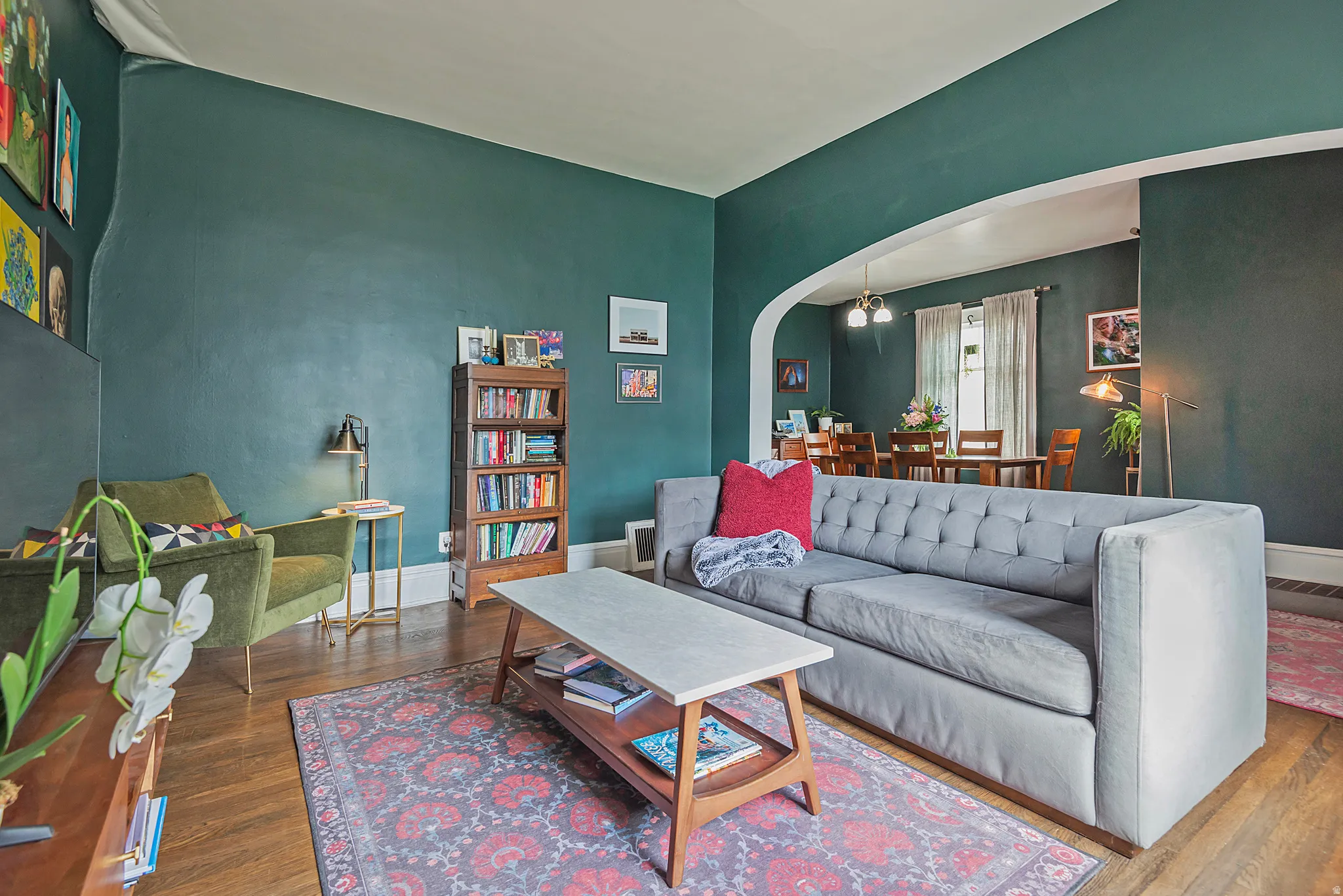 Living room with arched walkways and wood finished floors