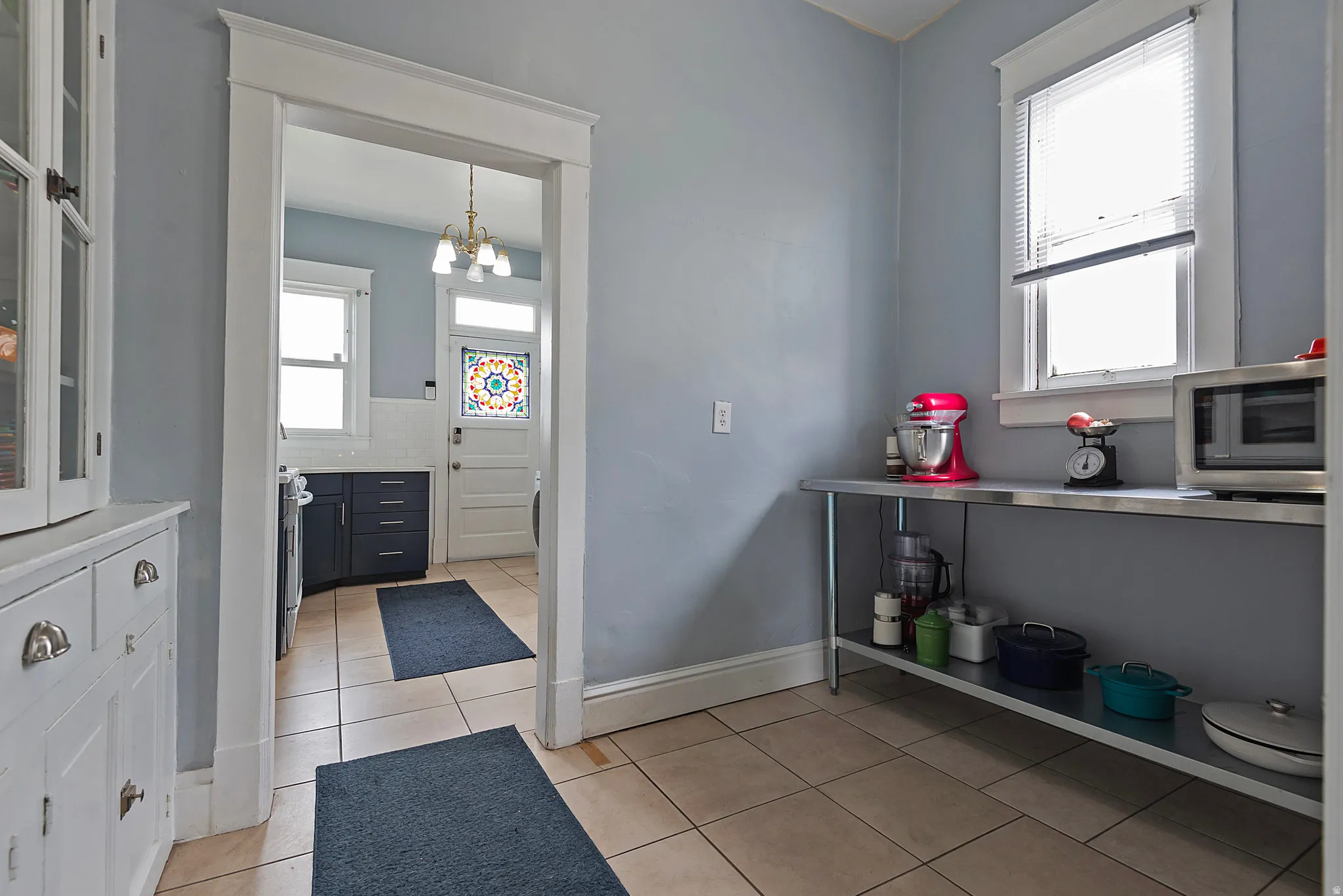 Kitchen featuring plenty of natural light, a chandelier, light tile patterned flooring, and stainless steel appliances