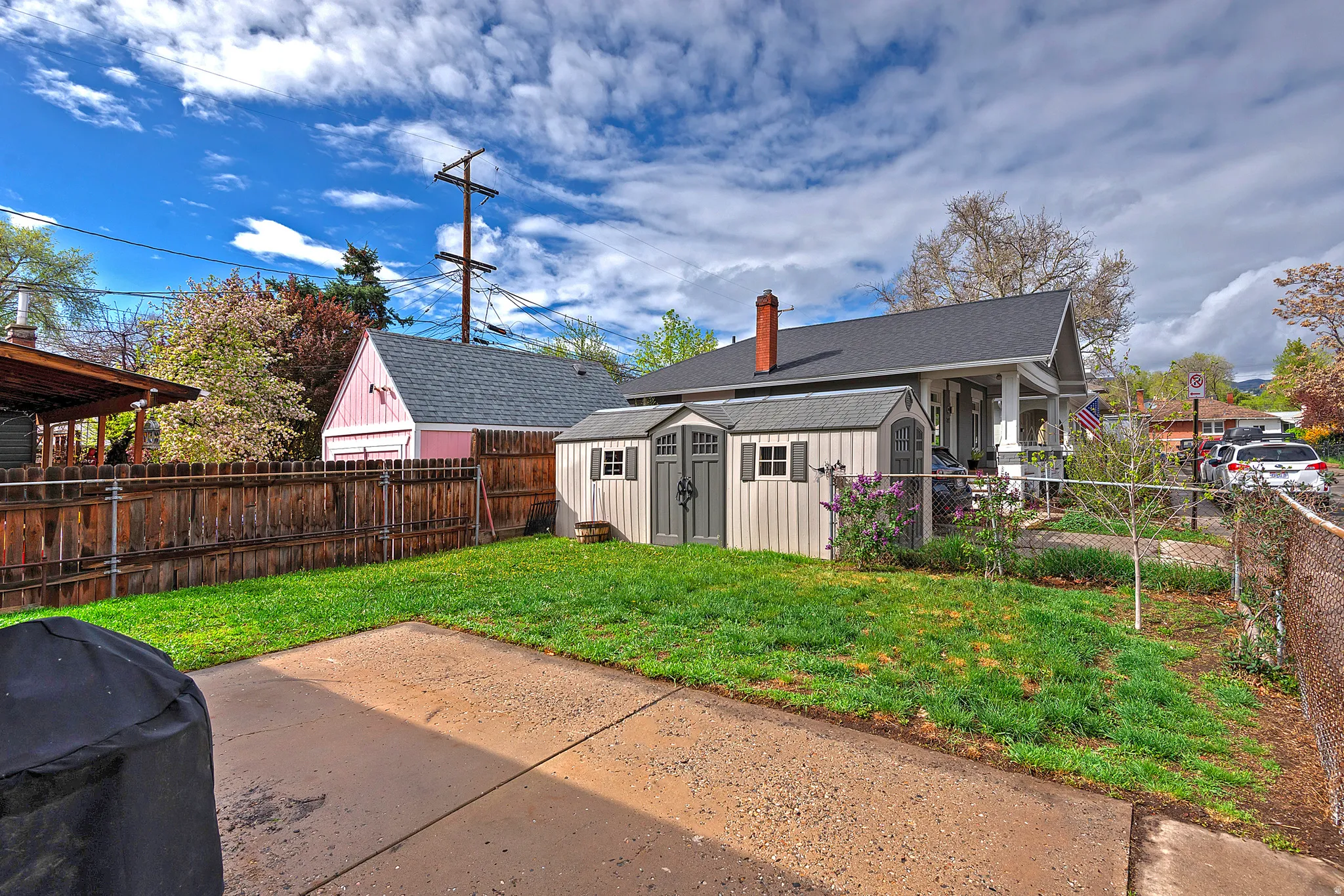 Rear view of house with a storage shed, a fenced backyard, and a chimney