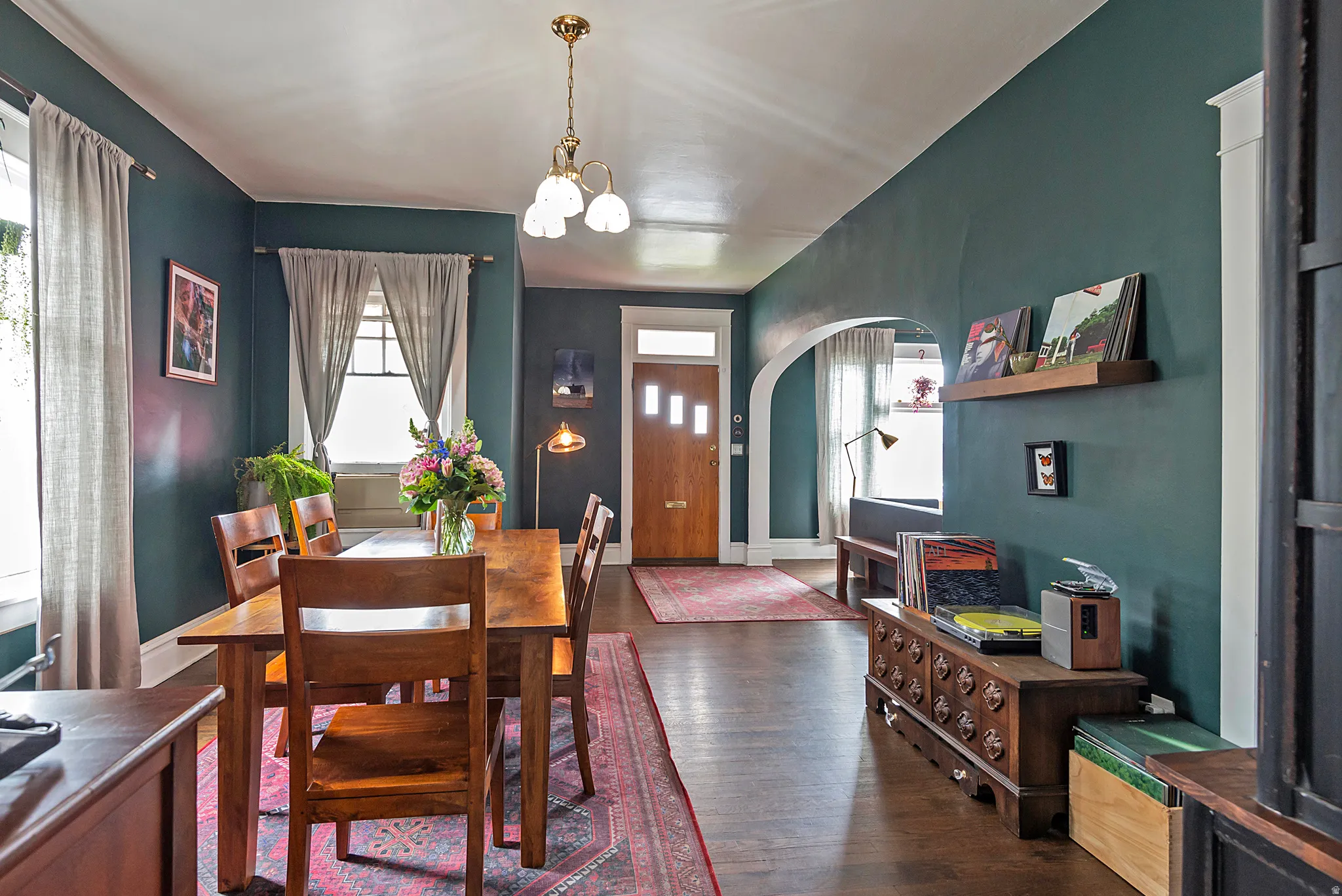 Dining area with arched walkways, dark wood-style flooring, healthy amount of natural light, and suspended lighting
