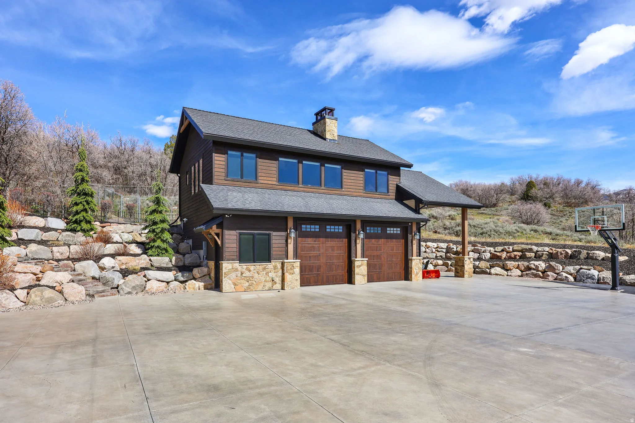 View of front of property with an attached garage, roof with shingles, driveway, and a chimney