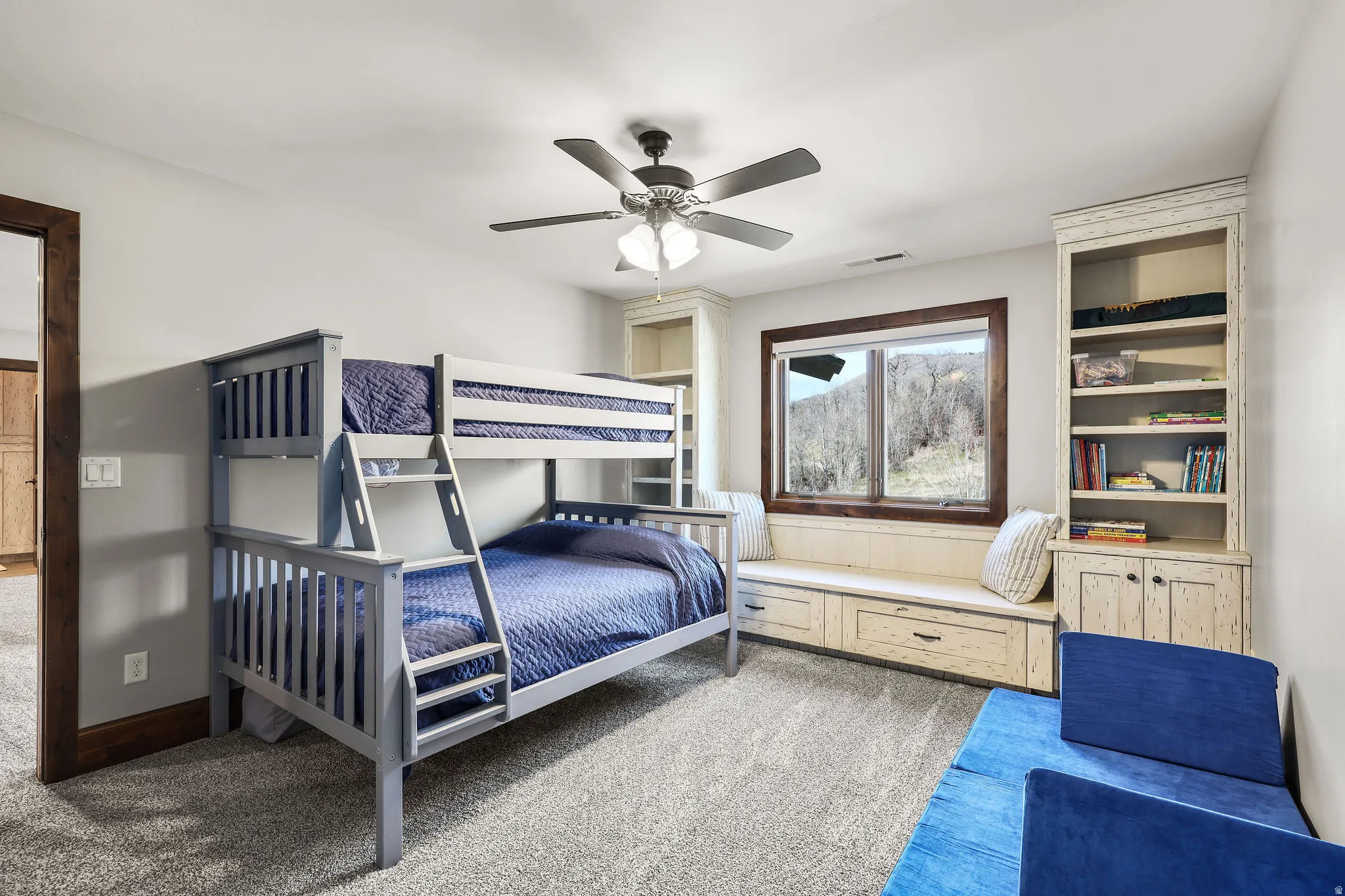 Bedroom with light colored carpet and a ceiling fan