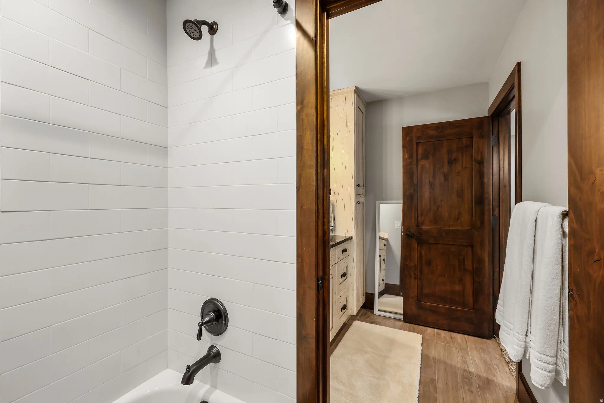 Bathroom featuring shower / tub combination and light wood-style floors