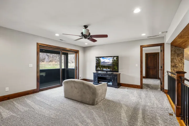 Living room featuring ceiling fan, light carpet, and recessed lighting
