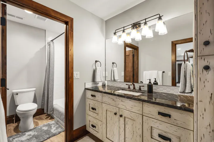 Full bath featuring vanity, shower / bath combination with curtain, and light wood finished floors