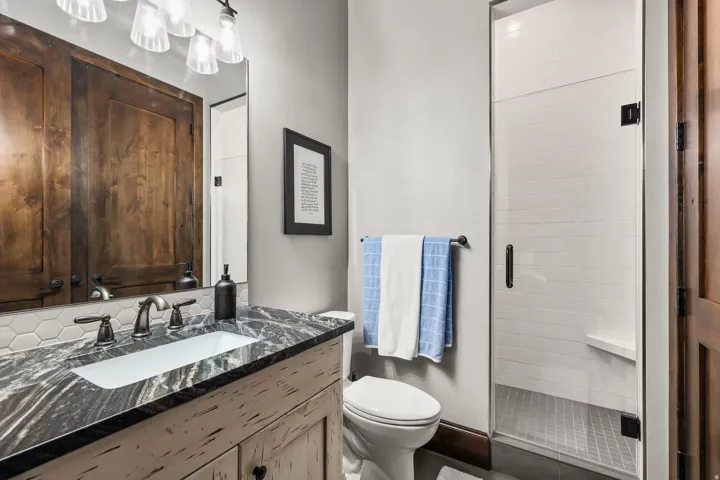 Full bathroom with vanity and a shower stall