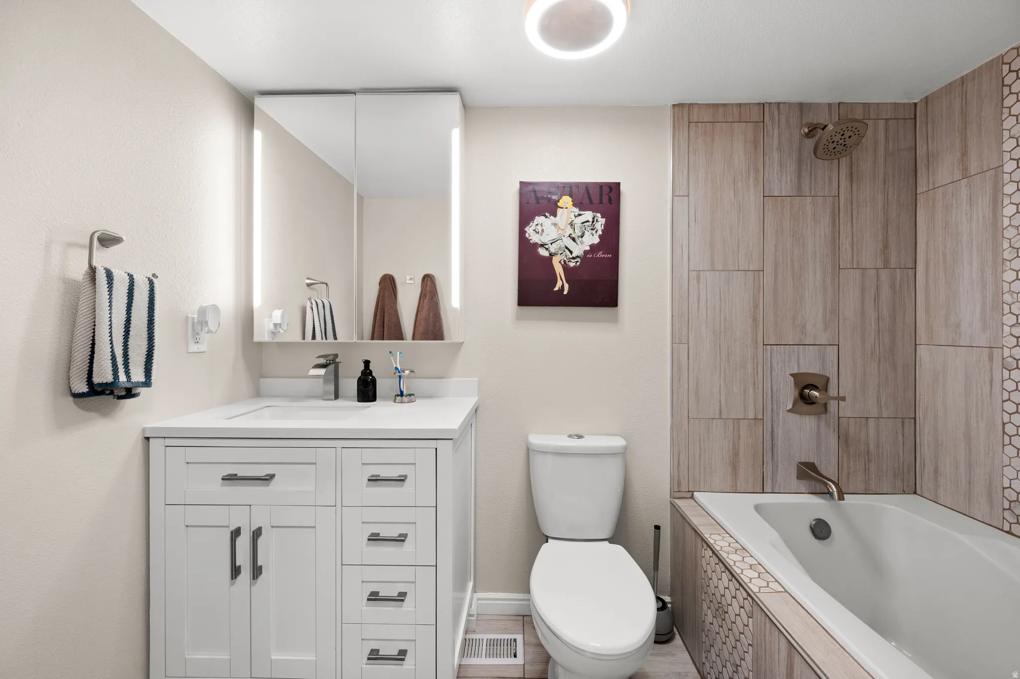 Full bathroom with tiled shower, deep soaker tub and vanity