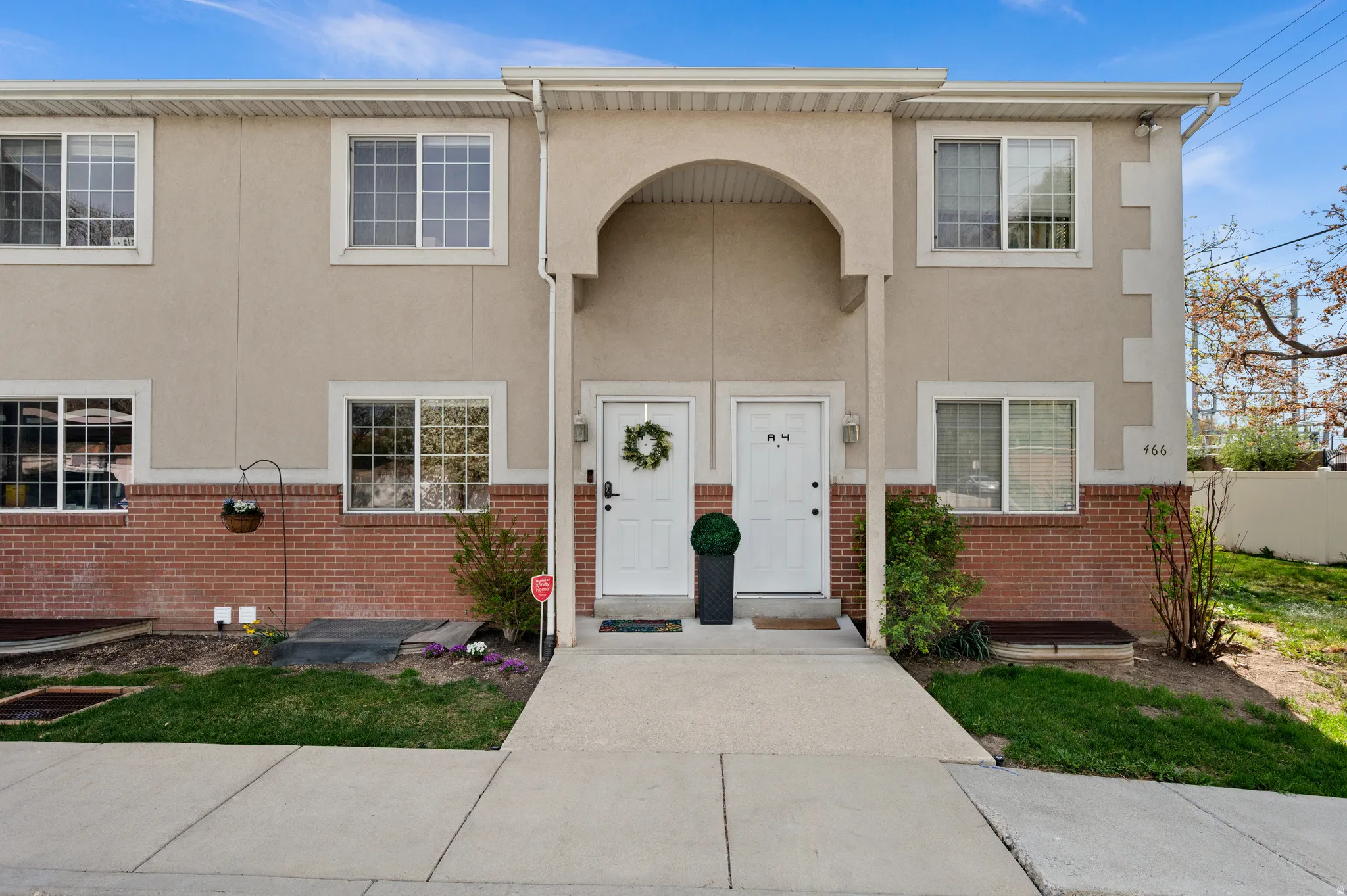 View of front of house with brick siding and stucco siding Door with wreath.