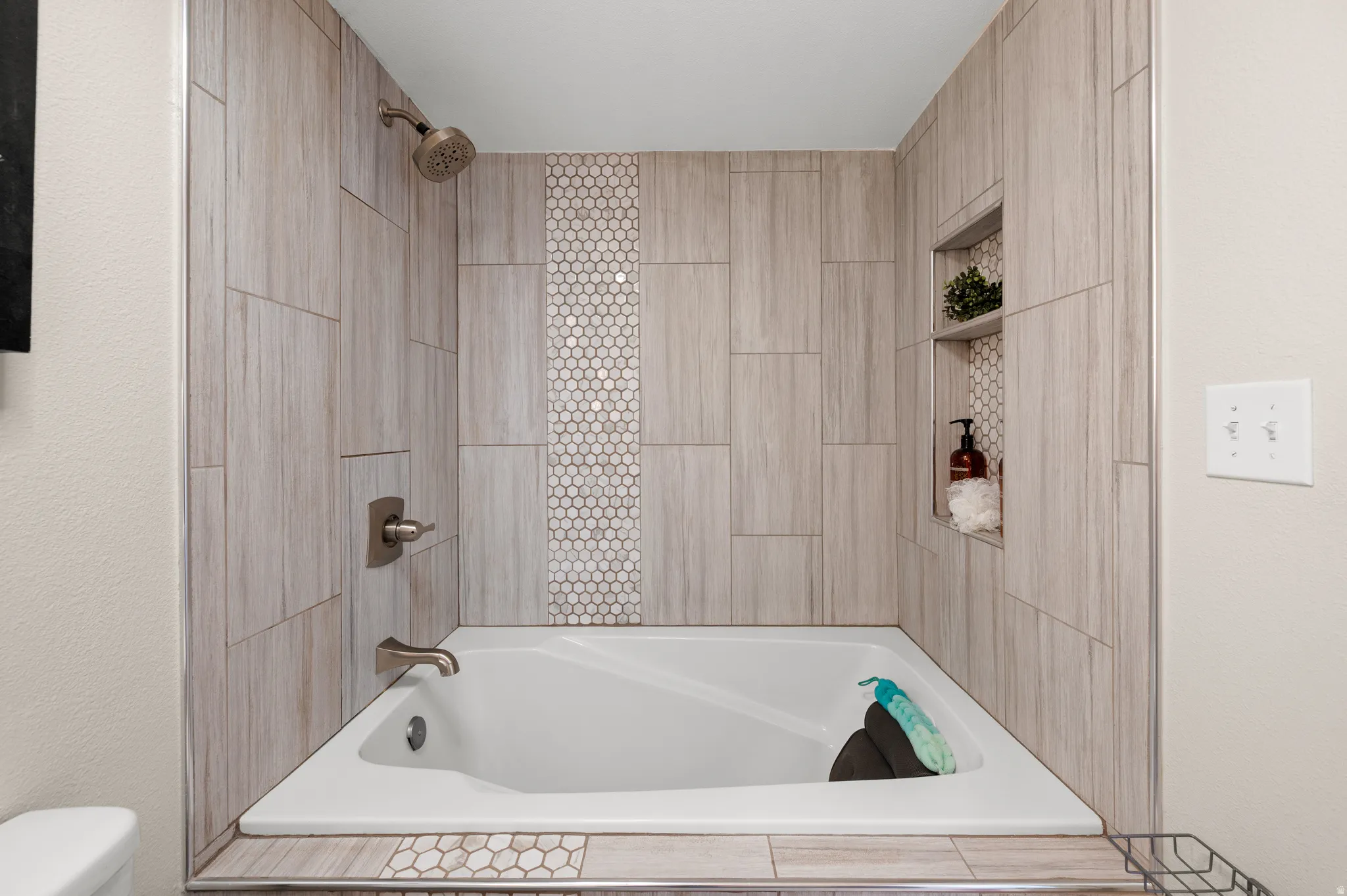 Full bath featuring shower / bath combination and built in niches.