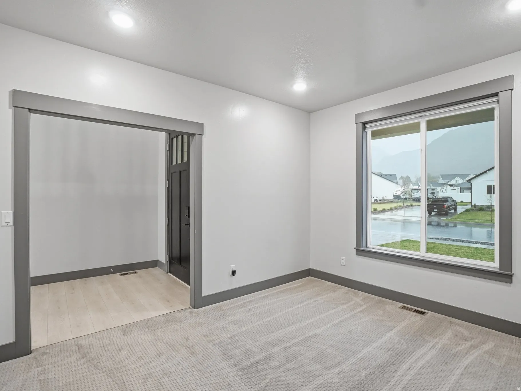 Empty room featuring light colored carpet and a water view