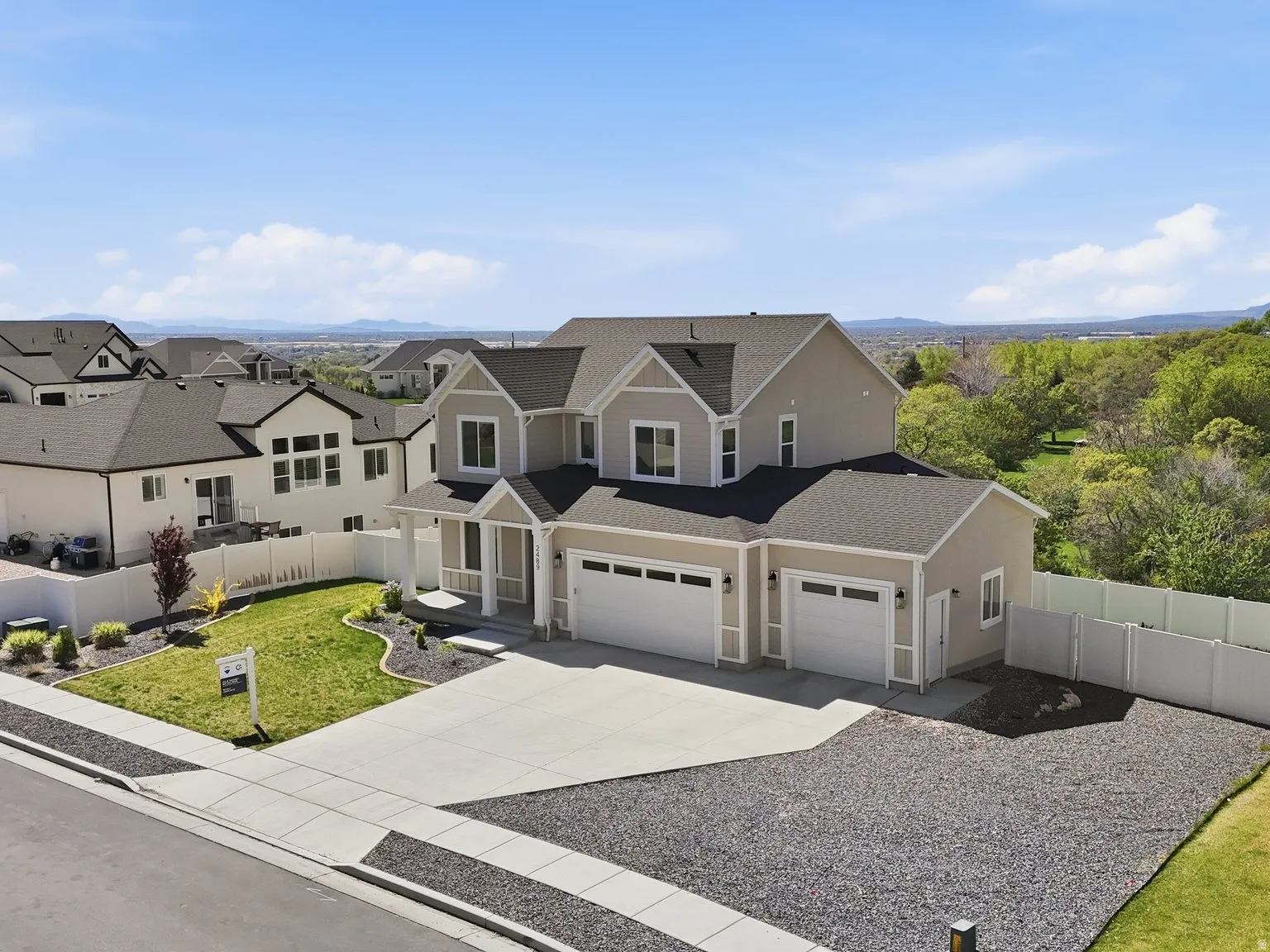 View of front of property with driveway, roof with shingles, and a residential view