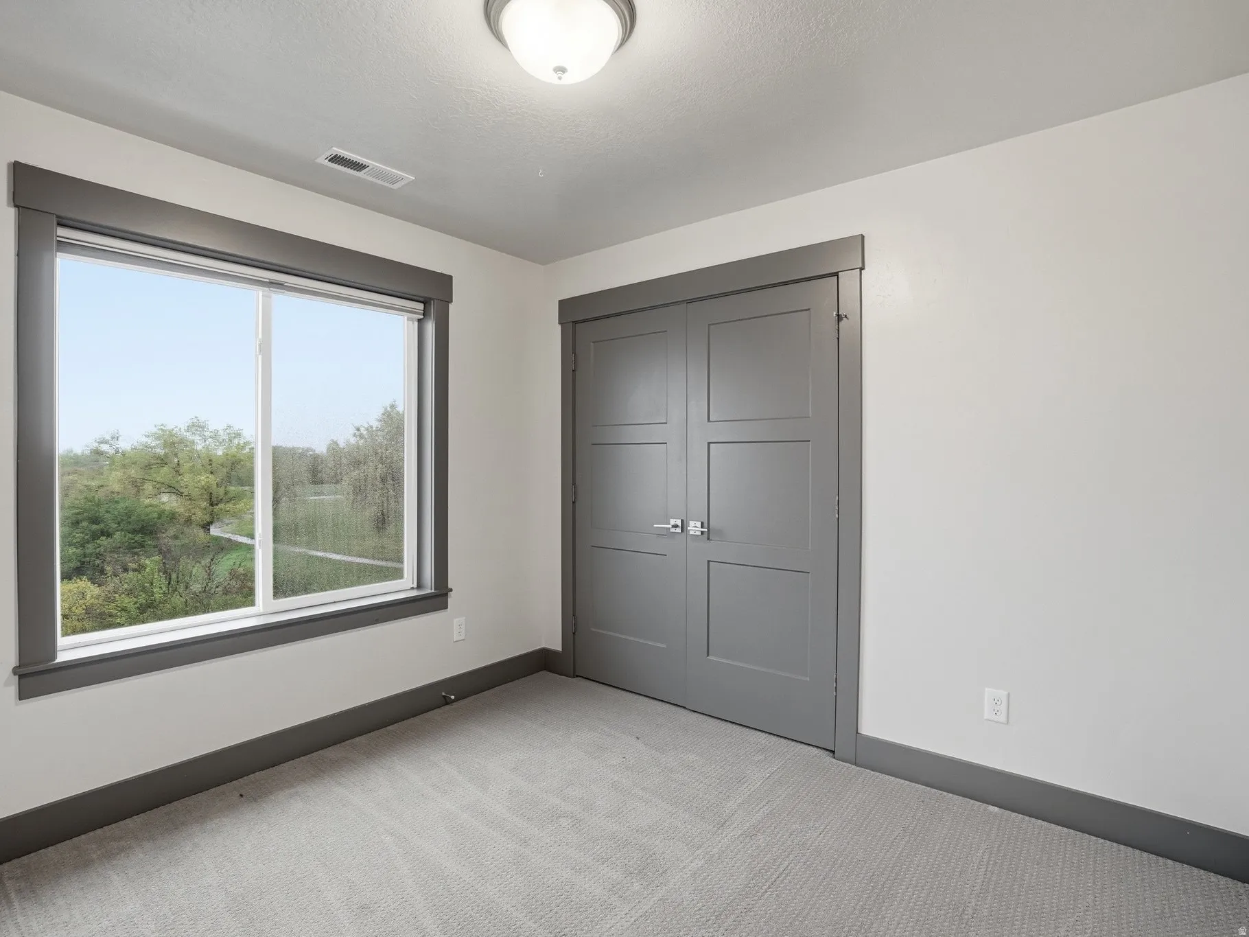 Unfurnished bedroom with light colored carpet and a closet