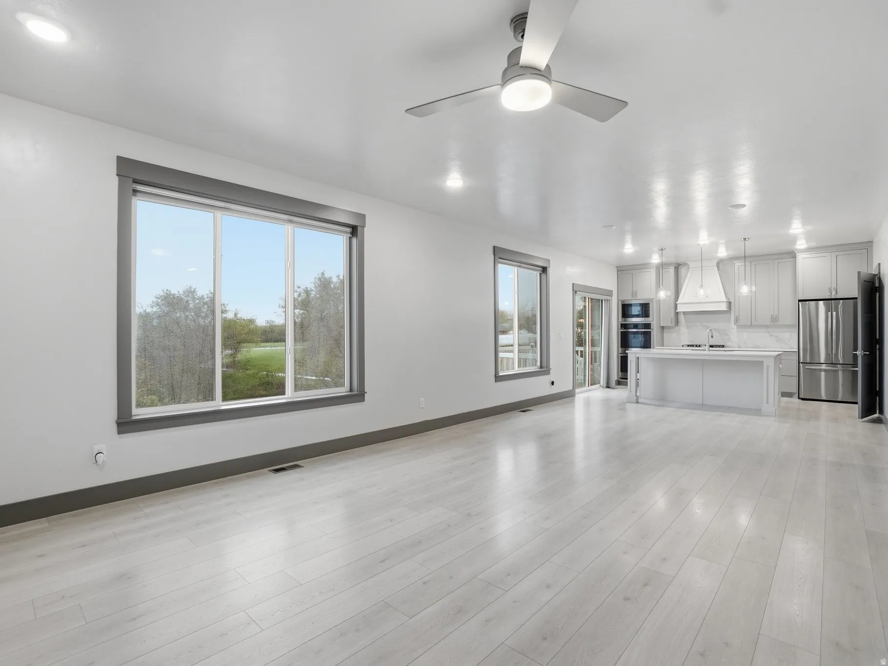 Unfurnished living room with a ceiling fan, light wood-type flooring, and recessed lighting