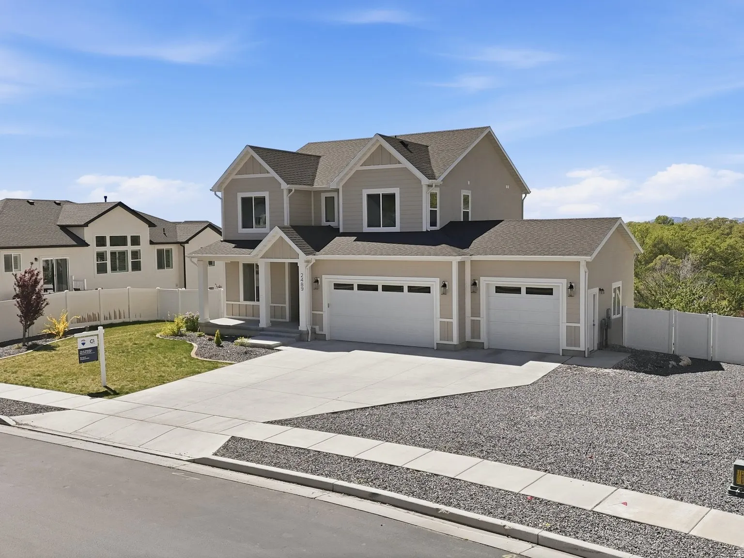 View of front of house with driveway, a garage, and a shingled roof