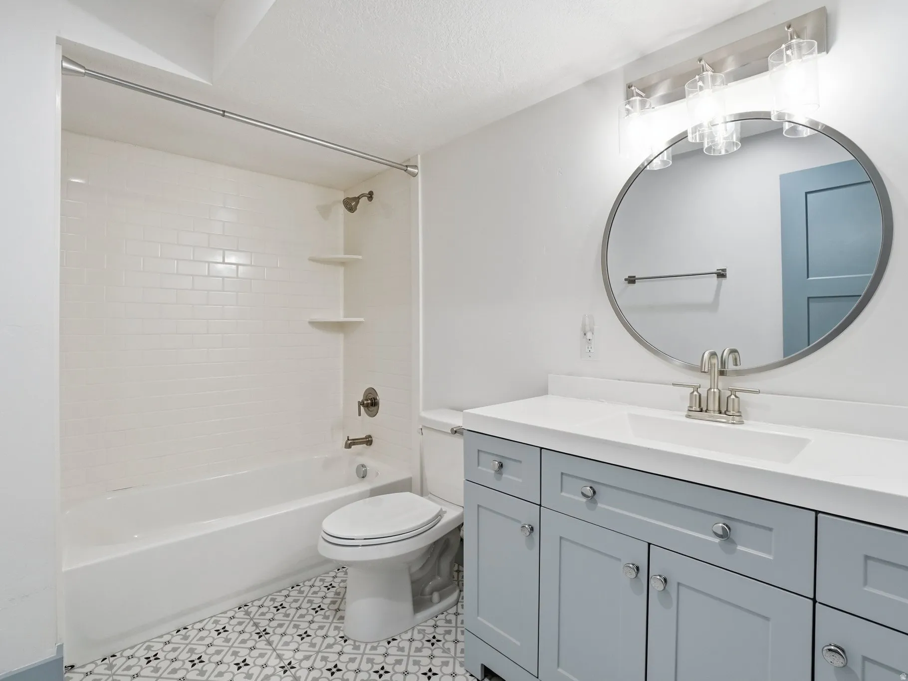 Full bath with vanity,  shower combination, and a textured ceiling