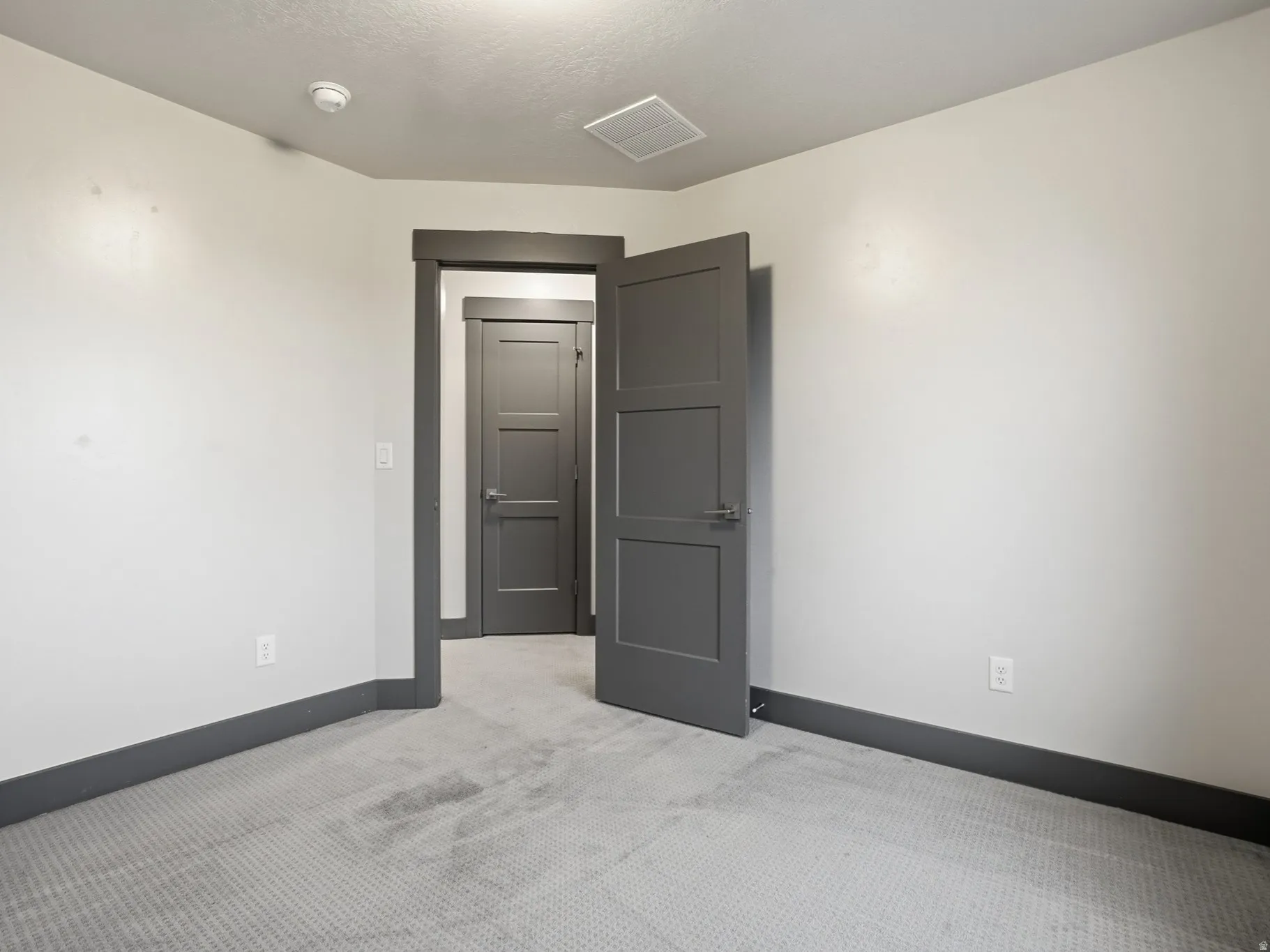 Spare room featuring light carpet and baseboards