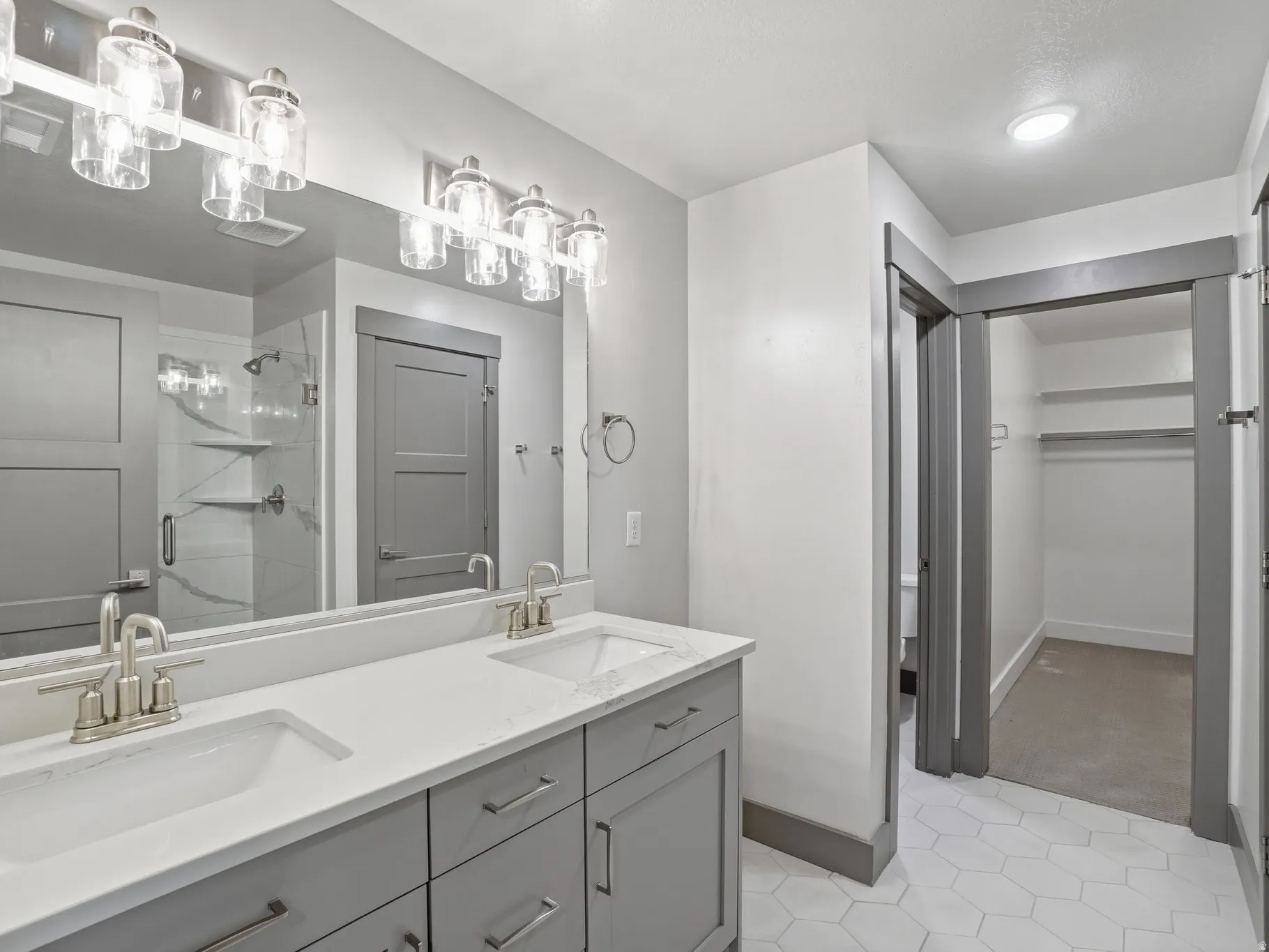 Bathroom featuring double vanity and a shower stall