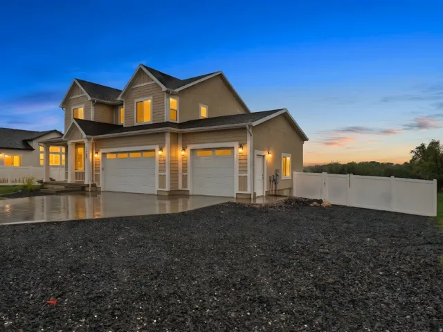 View of front of home with concrete driveway, an attached garage, and a garage