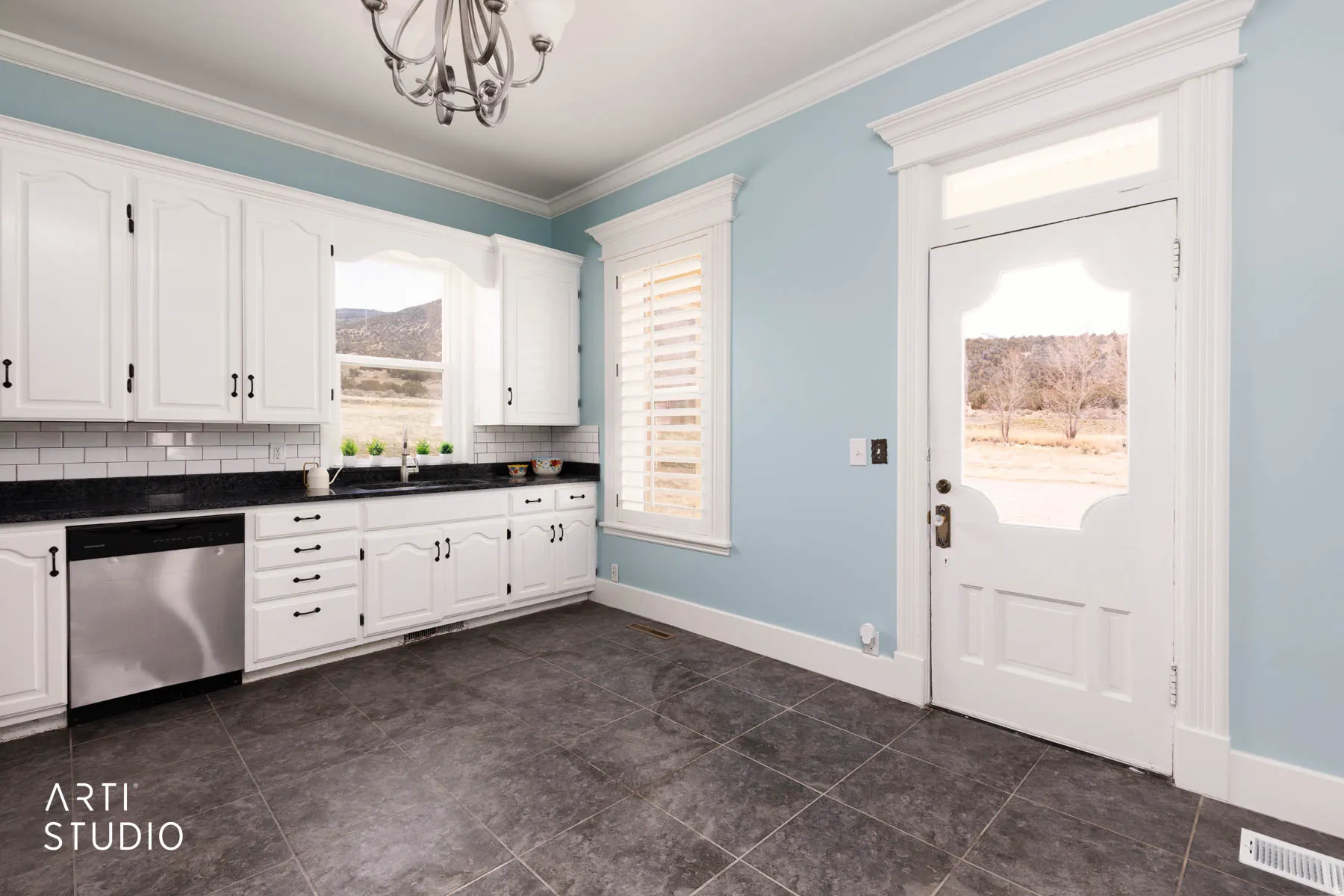 Kitchen with stainless steel dishwasher, white cabinets, ornamental molding, hanging lights, and tasteful backsplash
