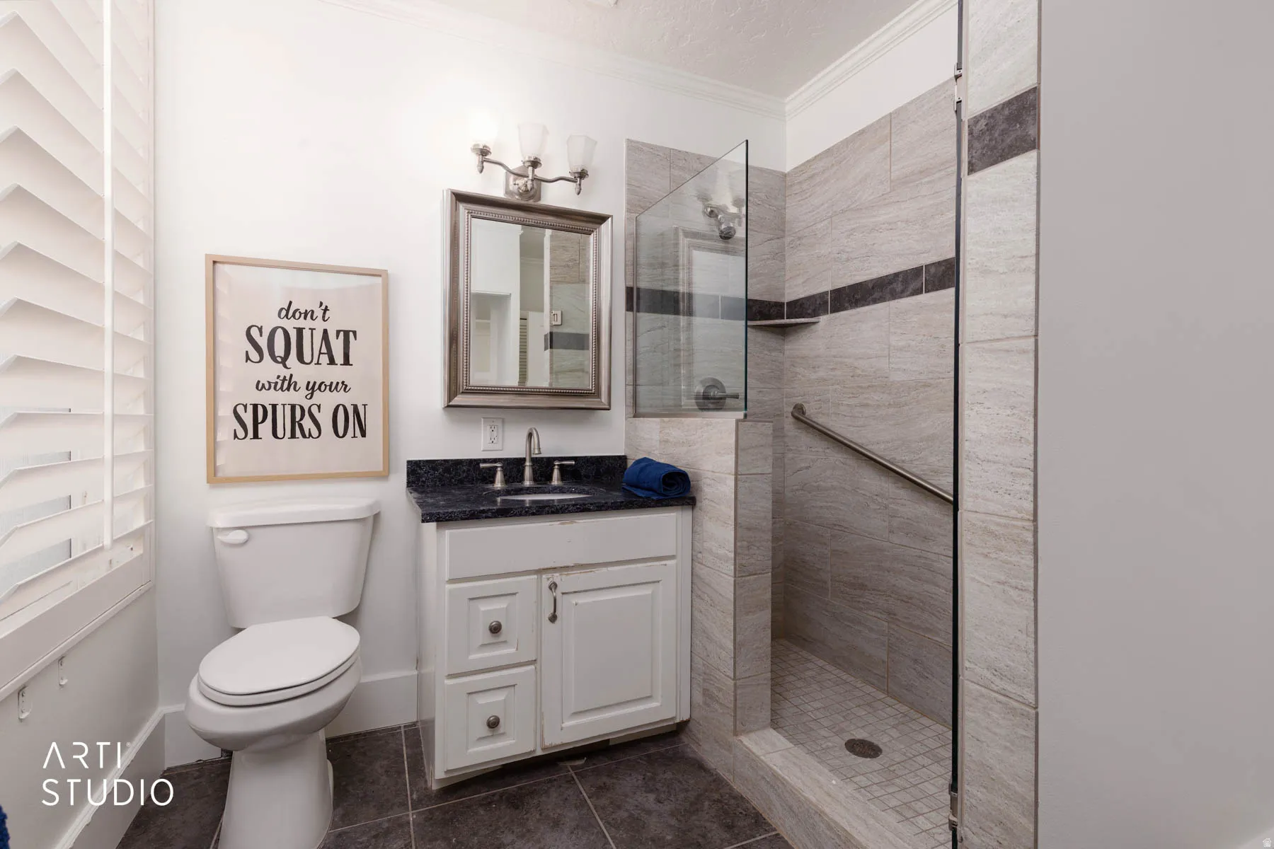 Bathroom with vanity, a walk in shower, crown molding, and dark tile patterned floors