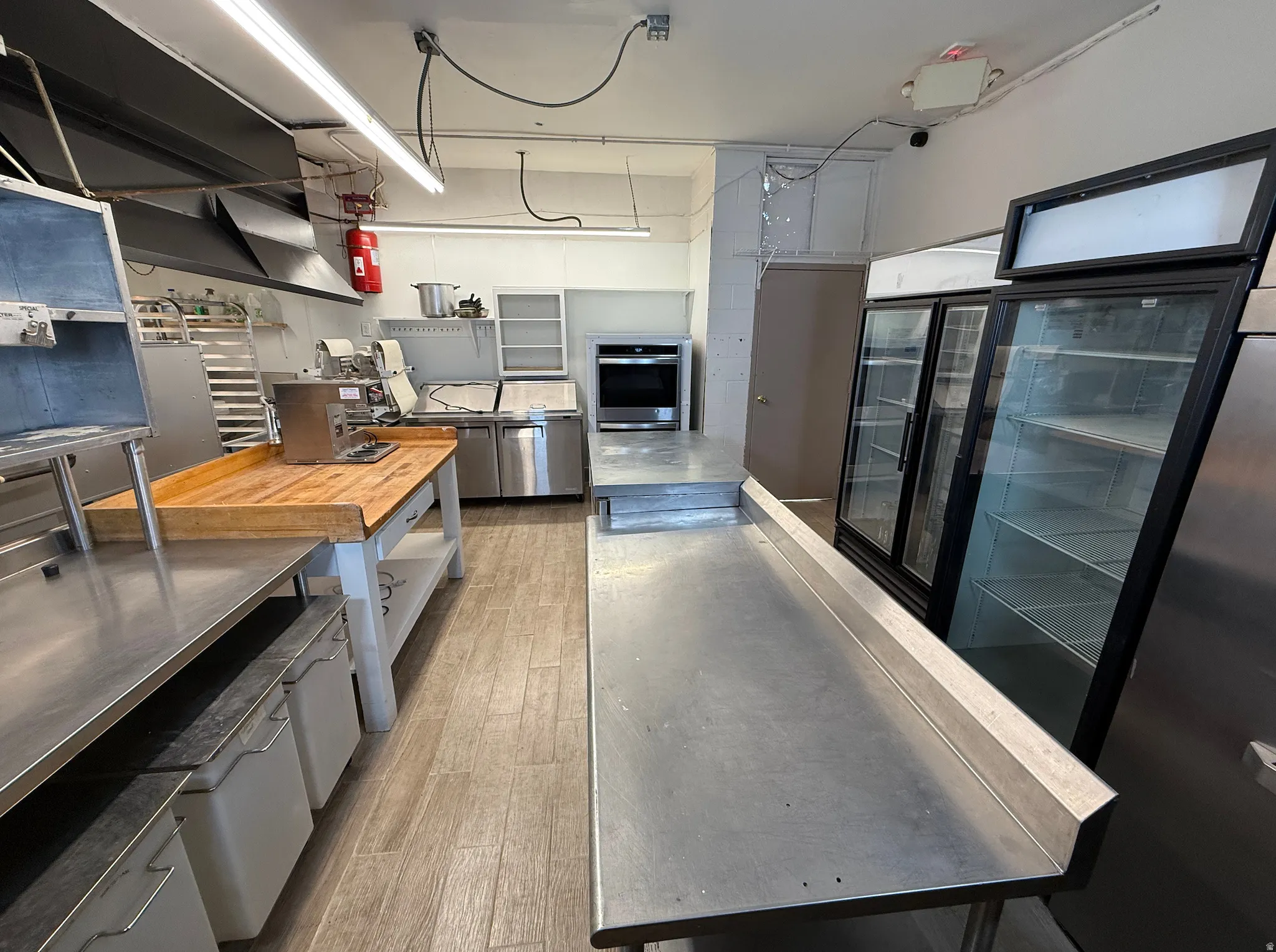 Kitchen with stainless steel countertops, open shelves, and gray cabinets