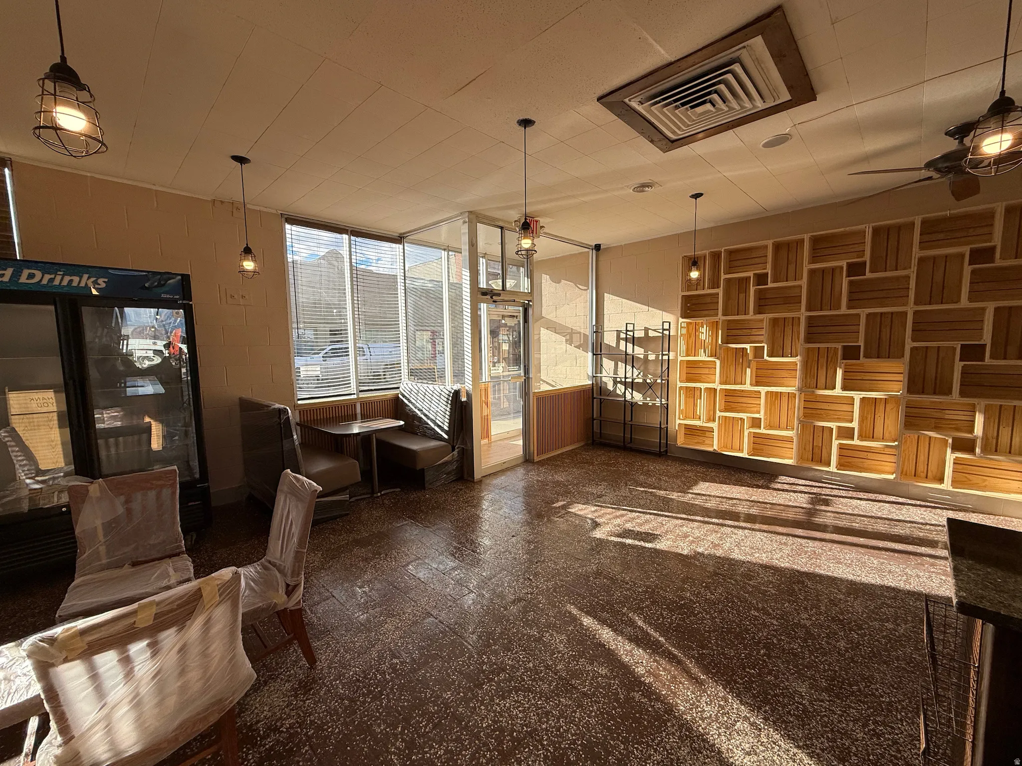 Interior space featuring a ceiling fan and concrete block wall